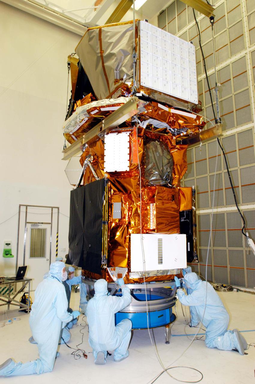 KENNEDY SPACE CENTER, FLA. - Technicians at NASA’s Hangar AE, Cape Canaveral Air Force Station (CCAFS), check the attachment of the Swift spacecraft to the payload attach fitting, the interface between the spacecraft and the second stage of the Boeing Delta II rocket. Swift is a first-of-its-kind multi-wavelength observatory dedicated to the study of gamma-ray burst (GRB) science. Its three instruments will work together to observe GRBs and afterglows in the gamma ray, X-ray, ultraviolet and optical wavebands. Swift is expected to observe more than 200 gamma-ray bursts - the most comprehensive study of GRB afterglows to date - during its 2-year mission. Swift is scheduled to launch in November from Launch Pad 17-A at CCAFS.