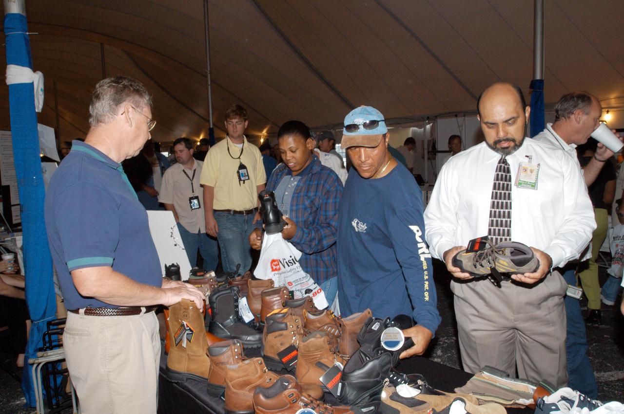 KENNEDY SPACE CENTER, FLA. -   Inside a tent, employees look over an exhibit of work shoes.  The exhibits were part of Spaceport Super Safety and Health Day, which also featured presentations by guest speakers Dr. Pamela Peeke, Navy Com. Stephen E. Iwanowicz, NASA’s Dr. Kristine Calderon and Olympic-great Bruce Jenner.   Vendors’ exhibits were set up in the parking areas outside the Vehicle Assembly Building and the OandC Building. The annual event was initiated at KSC in 1998 to increase awareness of the importance of safety and health among the government and contractor workforce.  The theme for this year’s event was “Safety and Health: A Winning Combination.”