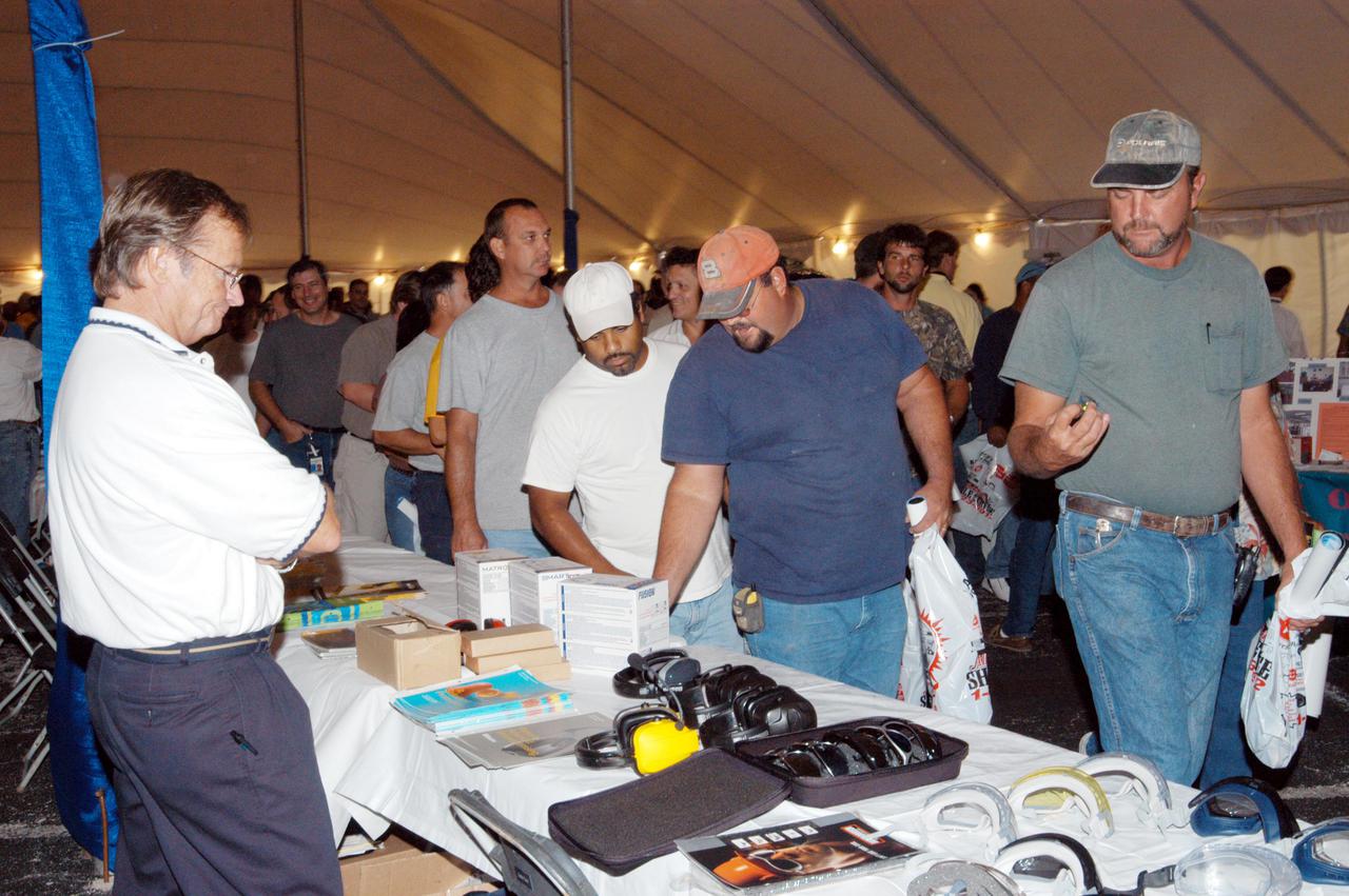 KENNEDY SPACE CENTER, FLA. -   Inside a tent, employees look over an exhibit of safety equipment. The exhibits were part of Spaceport Super Safety and Health Day, which also featured presentations by guest speakers Dr. Pamela Peeke, Navy Com. Stephen E. Iwanowicz, NASA’s Dr. Kristine Calderon and Olympic-great Bruce Jenner.   Vendors’ exhibits were set up in the parking areas outside the Vehicle Assembly Building and the OandC Building. The annual event was initiated at KSC in 1998 to increase awareness of the importance of safety and health among the government and contractor workforce.  The theme for this year’s event was “Safety and Health: A Winning Combination.”