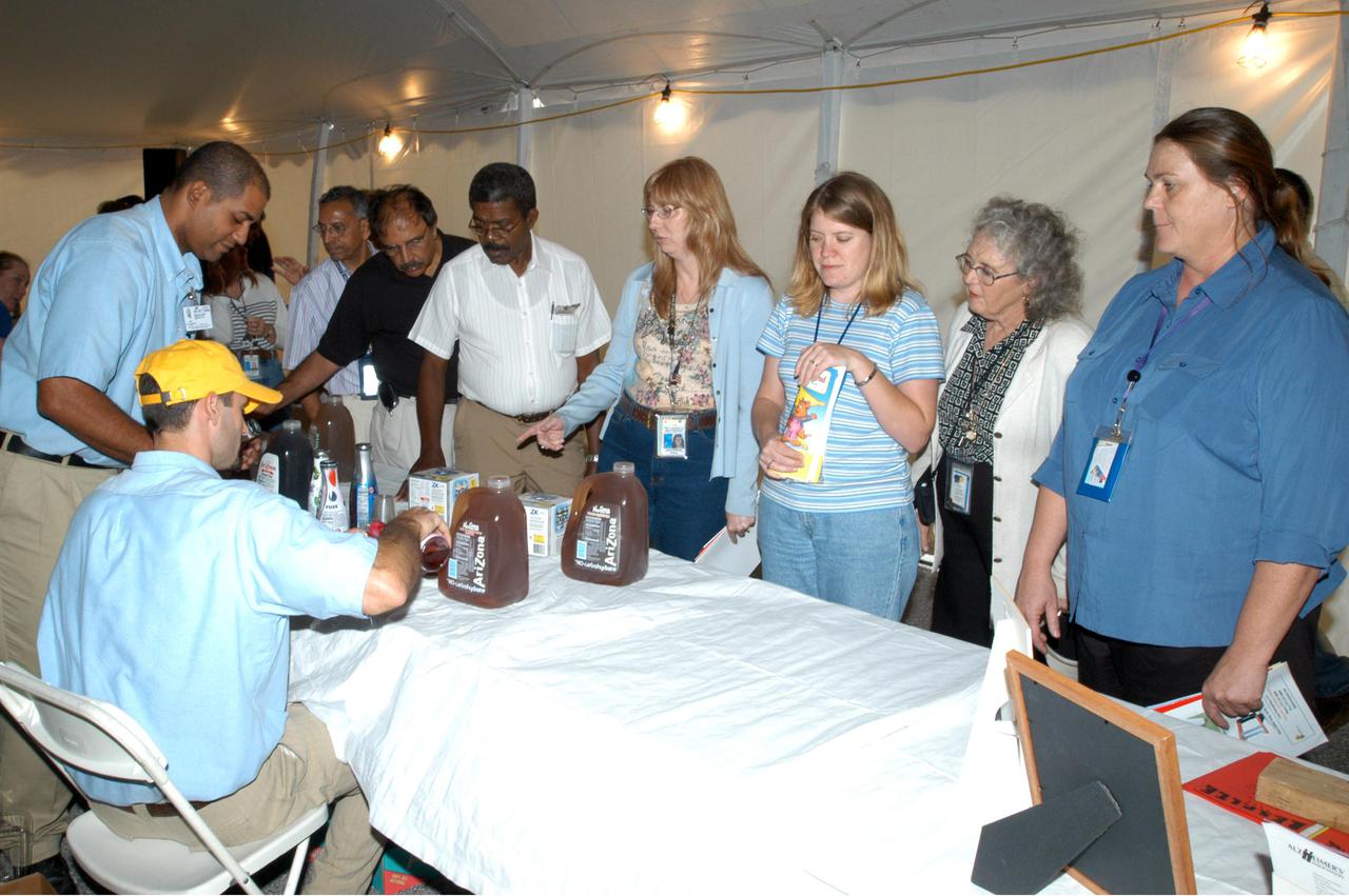 KENNEDY SPACE CENTER, FLA. -  KSC employees stop at a table with a display of juices during Spaceport Super Safety and Health Day. The event included guest speakers Dr. Pamela Peeke, Navy Com. Stephen E. Iwanowicz, NASA’s Dr. Kristine Calderon and Olympic-great Bruce Jenner.  In addition, many vendors’ exhibits were on display for employees.  Super Safety and Health Day was initiated at KSC in 1998 to increase awareness of the importance of safety and health among the government and contractor workforce.  The theme for this year’s event was “Safety and Health: A Winning Combination.”