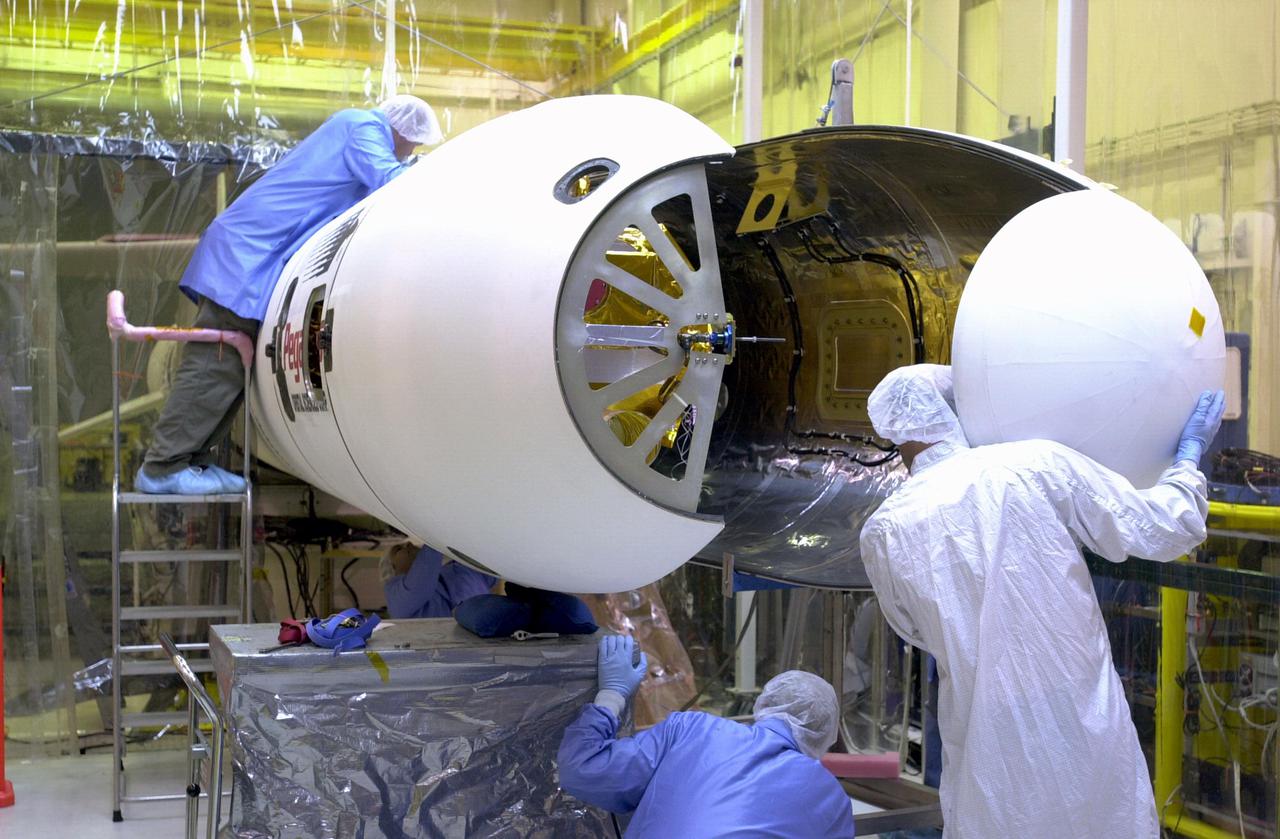 KENNEDY SPACE CENTER, FLA. - Orbital Sciences Corporation technicians at Vandenberg AFB in California maneuver the second fairing half into place around the Demonstration of Autonomous Rendezvous Technology (DART) spacecraft in preparation for launch. The fairing will encapsulate DART and protect it while on the launch pad and during ascent. DART was designed and built for NASA by Orbital Sciences as an advanced flight demonstrator to locate and maneuver near an orbiting satellite. The DART spacecraft weighs about 800 pounds and is nearly 6 feet long and 3 feet in diameter. From beneath the belly of the Orbital Sciences L-1011 aircraft, the Pegasus XL vehicle will launch DART into a circular polar orbit of approximately 475 miles. The DART satellite provides a key step in establishing autonomous rendezvous capabilities for the U.S. Space Program. While previous rendezvous and docking efforts have been piloted by astronauts, the unmanned DART satellite will have computers and cameras to perform its rendezvous functions.