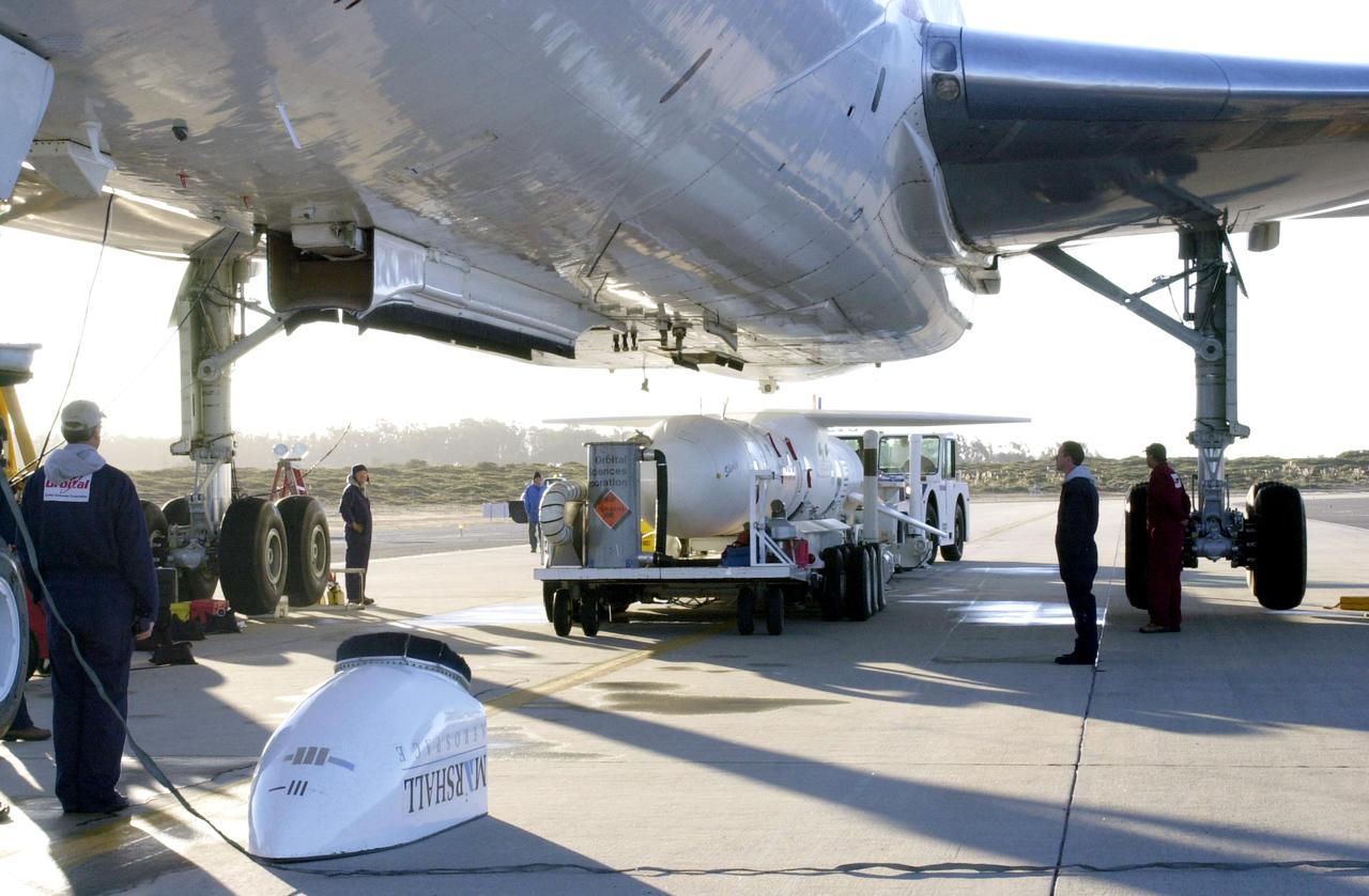 KENNEDY SPACE CENTER, FLA. - The Demonstration of Autonomous Rendezvous Technology (DART) spacecraft and Orbital Sciences Pegasus launch vehicle, mated earlier, arrive at the Vandenberg Air Force Base runway for mating to the belly of the Stargazer L-1011 aircraft (foreground). The Pegasus XL will launch DART at approximately 40,000 feet above the Pacific Ocean into a circular polar orbit of approximately 475 miles. DART was designed and built for NASA by Orbital Sciences as an advanced flight demonstrator to locate and maneuver near an orbiting satellite. The DART spacecraft weighs about 800 pounds and is nearly 6 feet long and 3 feet in diameter. The DART satellite provides a key step in establishing autonomous rendezvous capabilities for the U.S. Space Program. While previous rendezvous and docking efforts have been piloted by astronauts, the unmanned DART satellite will have computers and cameras to perform its rendezvous functions.