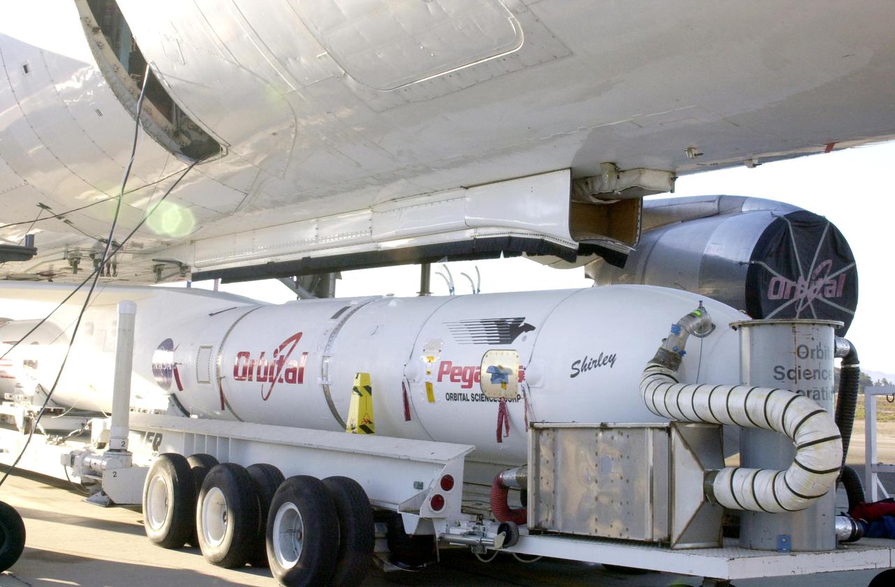 KENNEDY SPACE CENTER, FLA. - At Vandenberg Air Force Base in California, the Demonstration of Autonomous Rendezvous Technology (DART) spacecraft and Orbital Sciences Pegasus launch vehicle, mated earlier, are being attached to the Stargazer L-1011 aircraft above. The Pegasus XL will launch DART at approximately 40,000 feet above the Pacific Ocean into a circular polar orbit of approximately 475 miles. DART was designed and built for NASA by Orbital Sciences as an advanced flight demonstrator to locate and maneuver near an orbiting satellite. The DART spacecraft weighs about 800 pounds and is nearly 6 feet long and 3 feet in diameter. The DART satellite provides a key step in establishing autonomous rendezvous capabilities for the U.S. Space Program. While previous rendezvous and docking efforts have been piloted by astronauts, the unmanned DART satellite will have computers and cameras to perform its rendezvous functions.