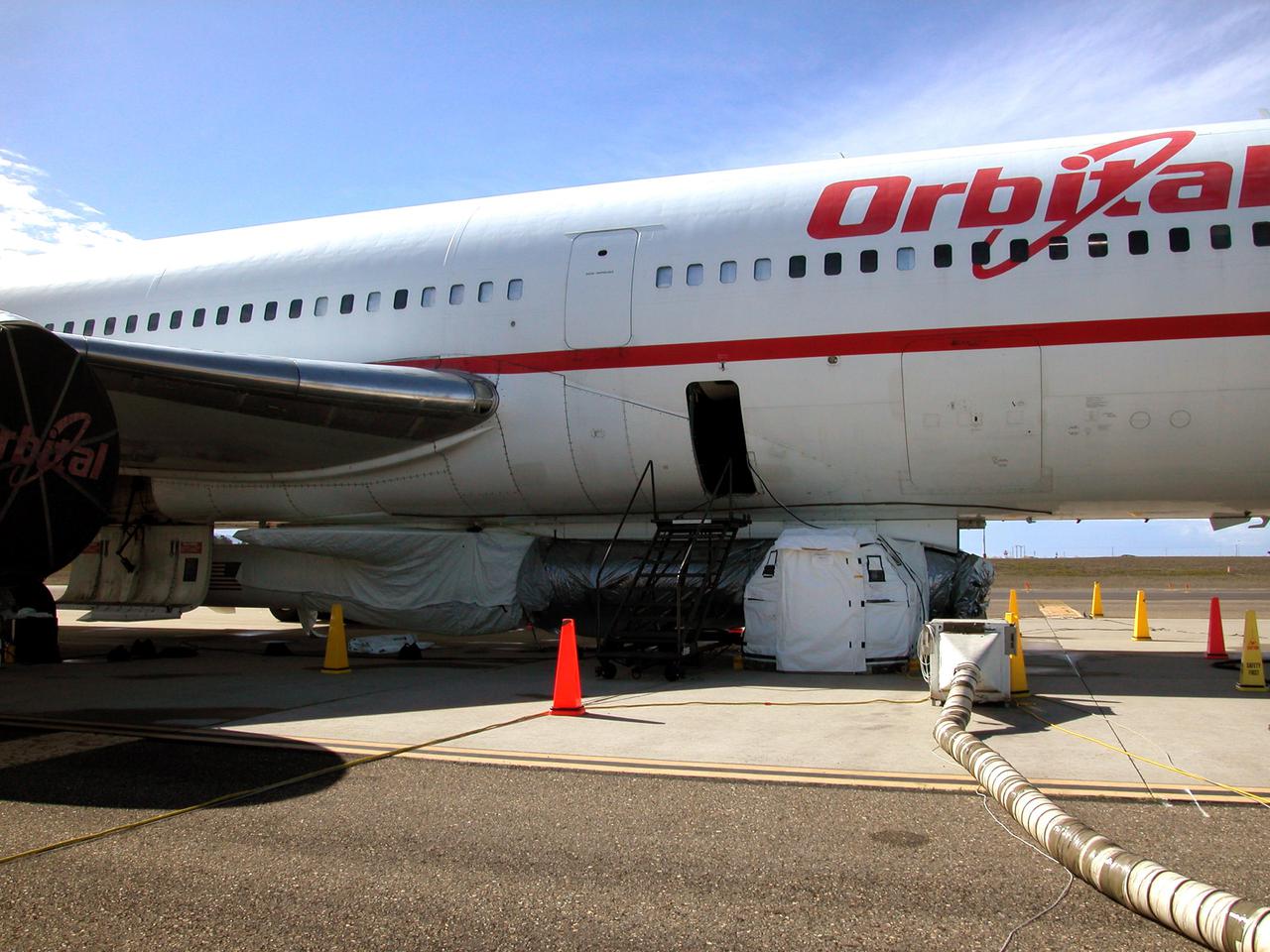 KENNEDY SPACE CENTER, FLA. - After postponement of the launch, the Demonstration of Autonomous Rendezvous Technology (DART) spacecraft is covered with protective material. DART is mated to Orbital Sciences Corporation’s Stargazer L-1011 aircraft, which will release its cargo over the Pacific Ocean at 40,000 feet. The Pegasus XL vehicle will launch DART into a circular polar orbit of approximately 475 miles. DART was designed and built for NASA by Orbital Sciences as an advanced flight demonstrator to locate and maneuver near an orbiting satellite. The DART satellite provides a key step in establishing autonomous rendezvous capabilities for the U.S. Space Program. While previous rendezvous and docking efforts have been piloted by astronauts, the unmanned DART satellite will have computers and cameras to perform its rendezvous functions.