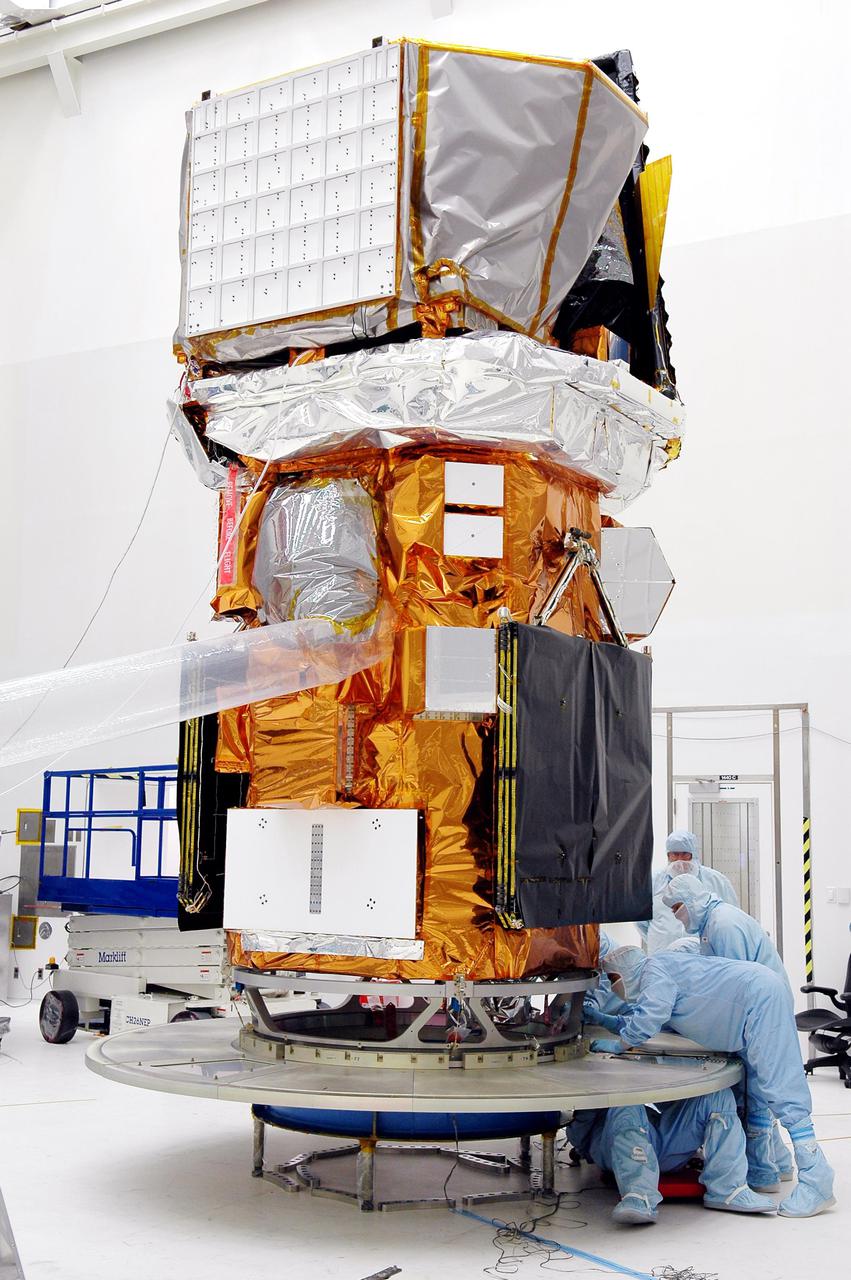 KENNEDY SPACE CENTER, FLA. - At NASA’s Hangar AE on Cape Canaveral Air Force Station (CCAFS), Fla., technicians check the attachment of the base petals of a transportation canister around the bottom of the payload attach fitting on the Swift spacecraft. Swift is a first-of-its-kind multi-wavelength observatory dedicated to the study of gamma-ray burst (GRB) science. Its three instruments will work together to observe GRBs and afterglows in the gamma ray, X-ray, ultraviolet and optical wavebands. Swift is expected to observe more than 200 gamma-ray bursts - the most comprehensive study of GRB afterglows to date - during its 2-year mission. Swift is scheduled to launch in mid-November from Launch Pad 17-A at CCAFS.