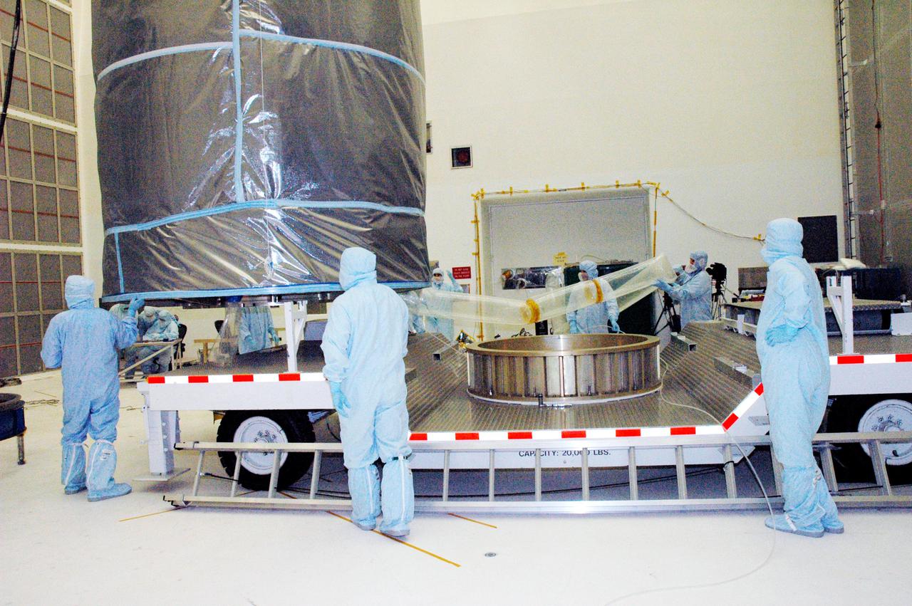 KENNEDY SPACE CENTER, FLA. - The Swift spacecraft, fully encased inside the payload transfer canister, is lifted onto a transport vehicle for a trip to the launch pad. The launch of the Swift observatory, a NASA spacecraft to pinpoint the location of gamma-ray bursts, is scheduled for Nov. 17 from Pad 17-A on CCAFS. Liftoff aboard a Boeing Delta II rocket is targeted at the opening of a one-hour launch window beginning at 12:09 p.m. EST. Gamma-ray bursts are distant, yet fleeting explosions that appear to signal the births of black holes. They are the most powerful explosions known in the universe, emitting more than 100 billion times the energy that the Sun emits in a year. Yet they last only from a few milliseconds to a few minutes, never to appear in the same spot again.