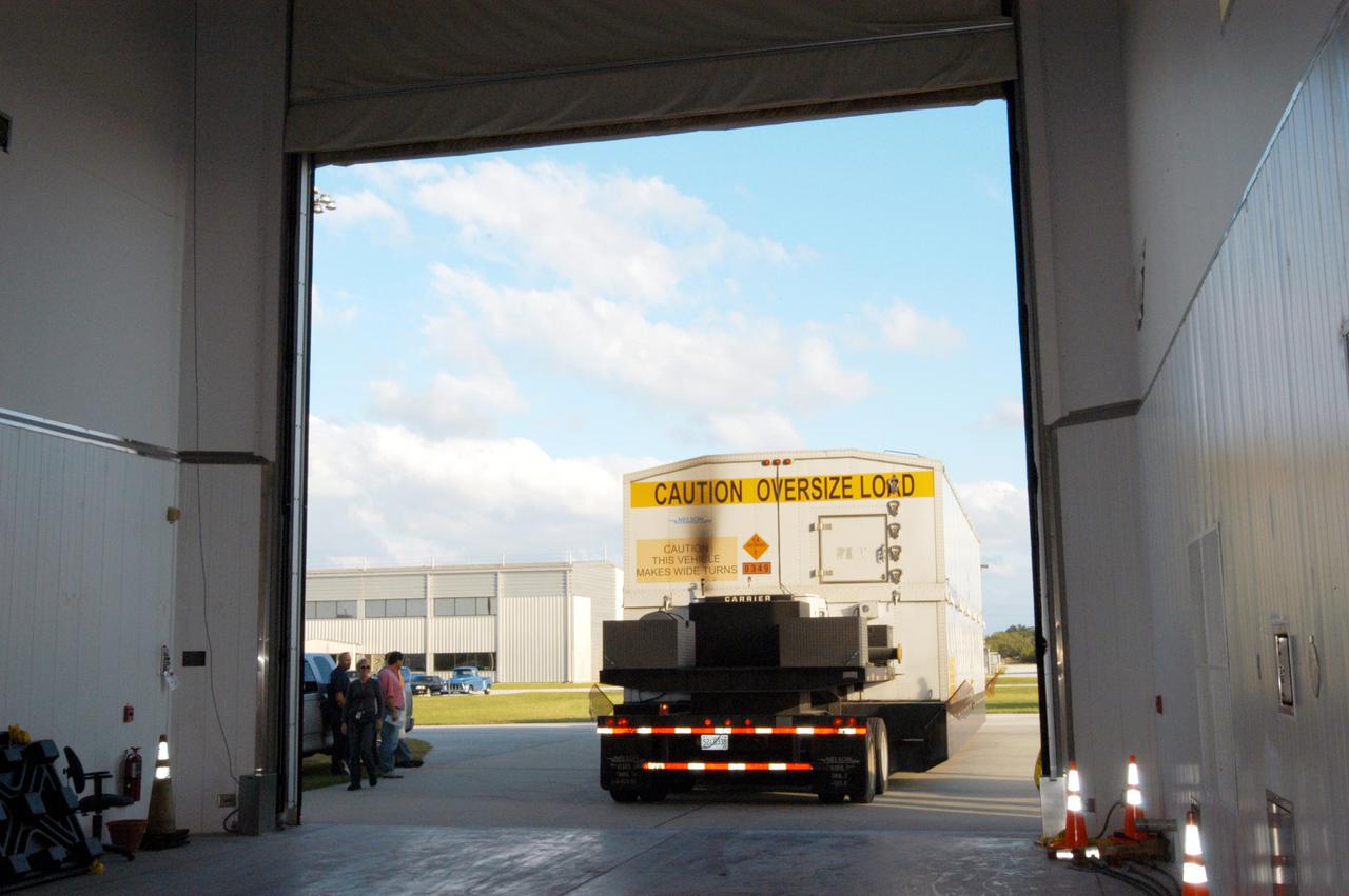 KENNEDY SPACE CENTER, FLA. - A truck carrying the second stage of a Boeing Delta IV launch vehicle arrives at the Boeing Delta Operations Center. The Delta IV rocket will be used for the 2005 launching of the GOES-N weather satellite for NASA and NOAA (National Oceanic and Atmospheric Administration). The first in a series of three advanced weather satellites including GOES-O and GOES-P, the GOES-N will provide continuous monitoring necessary for intensive data analysis. It will provide a constant vigil for the atmospheric “triggers” of severe weather conditions such as tornadoes, flash floods, hail storms and hurricanes. When these conditions develop, GOES-N will be able to monitor storm development and track their movements.