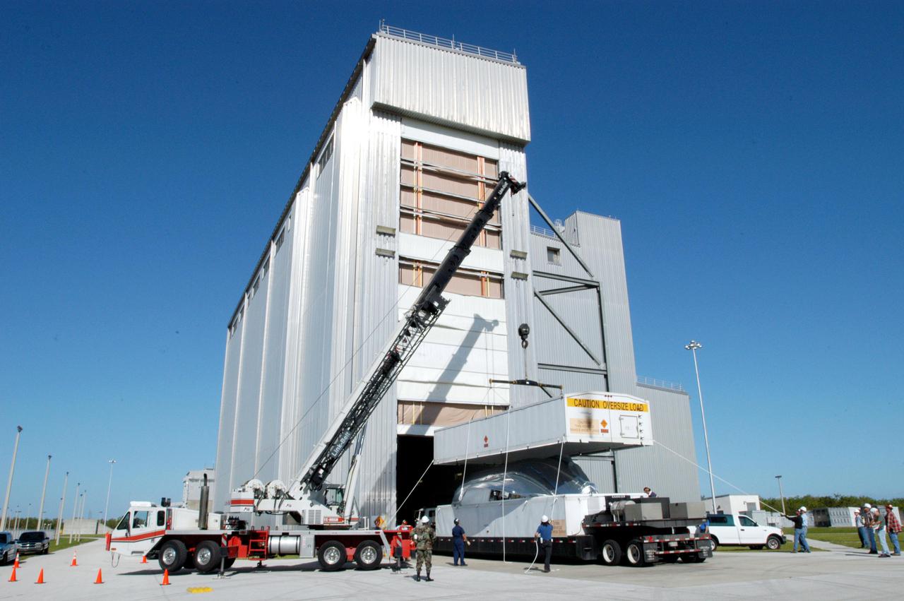 KENNEDY SPACE CENTER, FLA. -  At the Boeing Delta Operations Center, a crane lifts the top off the shipping container with the Boeing Delta IV second stage inside. The Delta IV rocket will be used for the 2005 launching of the GOES-N weather satellite for NASA and NOAA (National Oceanic and Atmospheric Administration).  The first in a series of three advanced weather satellites including GOES-O and GOES-P, the GOES-N will provide continuous monitoring necessary for intensive data analysis. It will provide a constant vigil for the atmospheric “triggers” of severe weather conditions such as tornadoes, flash floods, hail storms and hurricanes. When these conditions develop, GOES-N will be able to monitor storm development and track their movements.