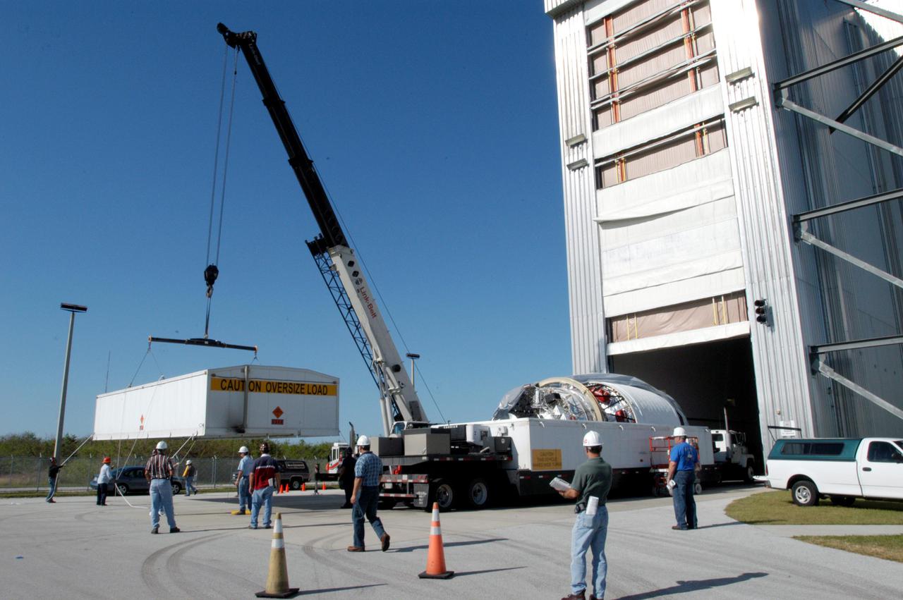 KENNEDY SPACE CENTER, FLA. -  At the Boeing Delta Operations Center, a crane moves to the ground the top of the shipping container at right.  The container holds the Boeing Delta IV second stage inside. The Delta IV rocket will be used for the 2005 launching of the GOES-N weather satellite for NASA and NOAA (National Oceanic and Atmospheric Administration).  The first in a series of three advanced weather satellites including GOES-O and GOES-P, the GOES-N will provide continuous monitoring necessary for intensive data analysis. It will provide a constant vigil for the atmospheric “triggers” of severe weather conditions such as tornadoes, flash floods, hail storms and hurricanes. When these conditions develop, GOES-N will be able to monitor storm development and track their movements.