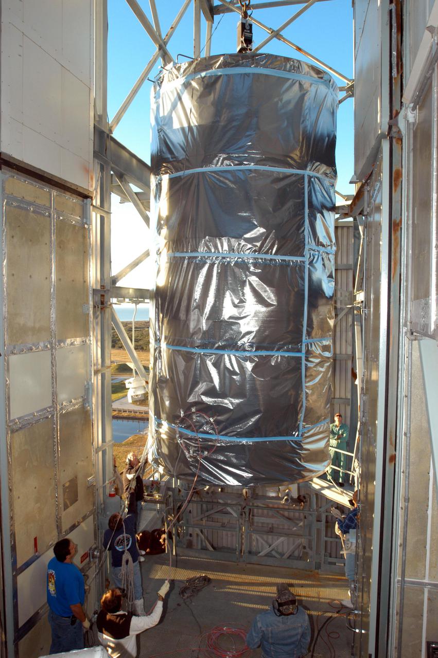 KENNEDY SPACE CENTER, FLA. - The Swift spacecraft arrives at the top of the mobile service tower at Launch Pad 17-A on Cape Canaveral Air Force Station in Florida. There it will be mated to the Boeing Delta II launch vehicle waiting there. Swift is scheduled to launch Nov. 17. The liftoff aboard a Boeing Delta II rocket is targeted at the opening of a one-hour launch window beginning at 12:09 p.m. EST. A first-of-its-kind multi-wavelength observatory dedicated to the study of gamma-ray burst (GRB) science, Swift’s three instruments will work together to observe GRBs and afterglows in the gamma ray, X-ray, ultraviolet and optical wavebands. Gamma-ray bursts are distant, yet fleeting explosions that appear to signal the births of black holes.