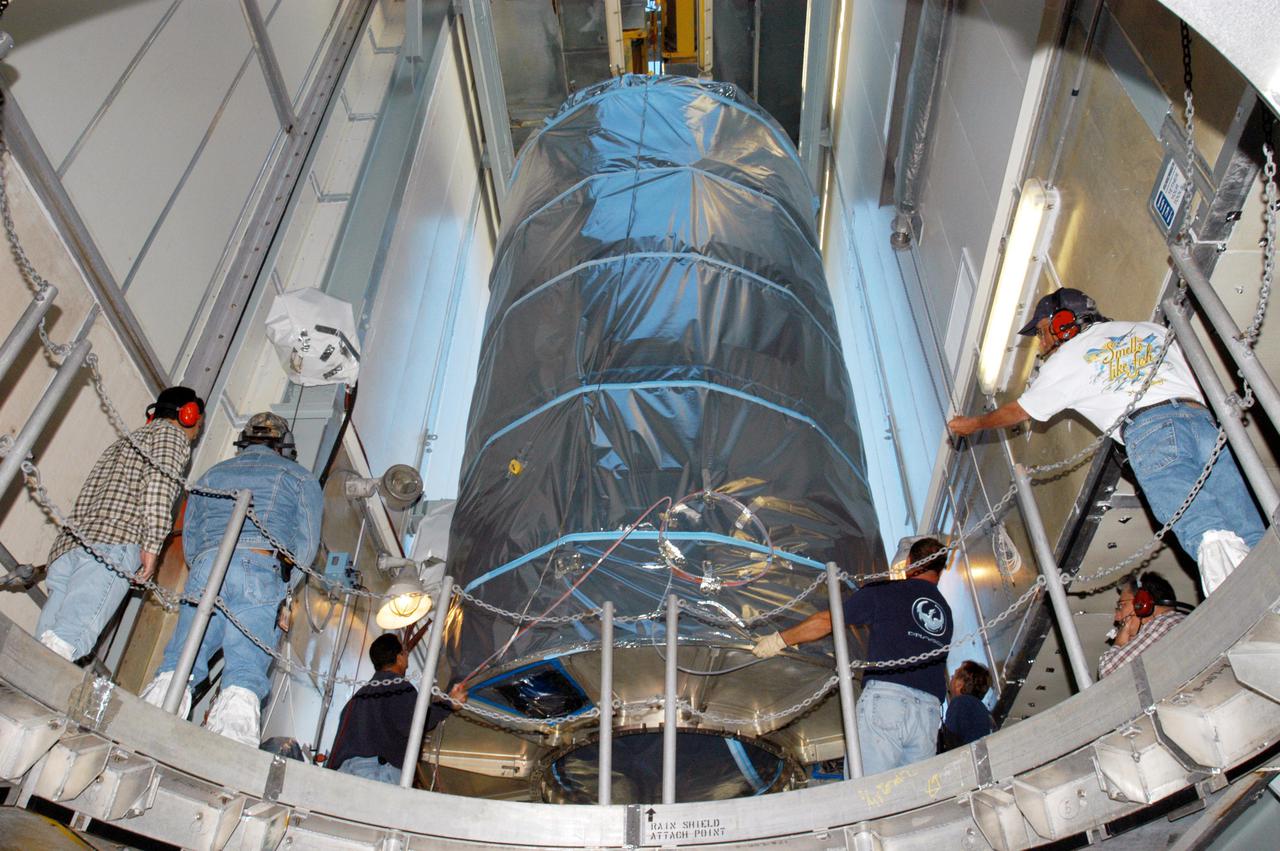 KENNEDY SPACE CENTER, FLA. - In the mobile service tower on Launch Pad 17-A, Cape Canaveral Air Force Station, Boeing technicians maneuver the Swift spacecraft into position to be lowered onto the Boeing Delta II launch vehicle for mating. Swift is scheduled to launch Nov. 17. The liftoff aboard a Boeing Delta II rocket is targeted at the opening of a one-hour launch window beginning at 12:09 p.m. EST. A first-of-its-kind multi-wavelength observatory dedicated to the study of gamma-ray burst (GRB) science, Swift’s three instruments will work together to observe GRBs and afterglows in the gamma ray, X-ray, ultraviolet and optical wavebands. Gamma-ray bursts are distant, yet fleeting explosions that appear to signal the births of black holes.
