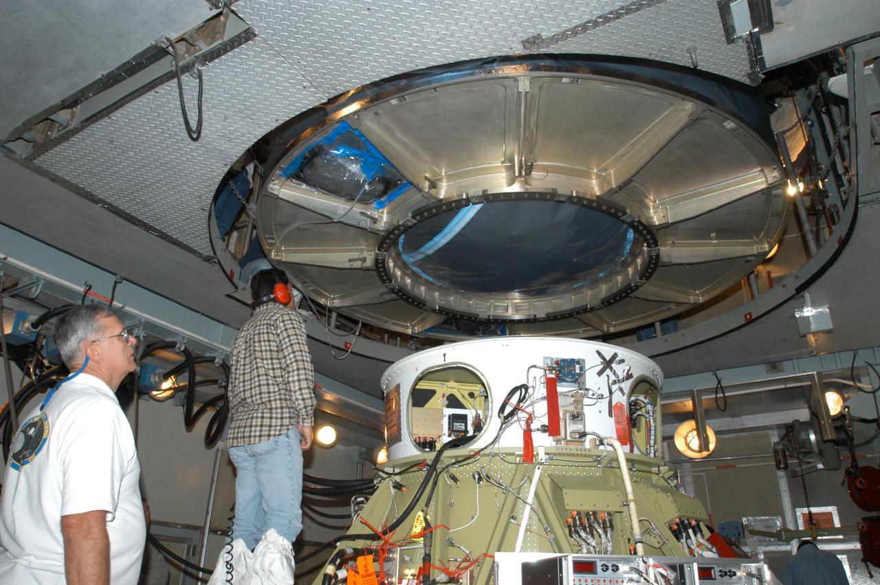 KENNEDY SPACE CENTER, FLA. - In the mobile service tower on Launch Pad 17-A, Cape Canaveral Air Force Station, Boeing technicians observe the lowering of the Swift spacecraft onto the Boeing Delta II second stage. Swift is scheduled to launch Nov. 17. The liftoff aboard a Boeing Delta II rocket is targeted at the opening of a one-hour launch window beginning at 12:09 p.m. EST. A first-of-its-kind multi-wavelength observatory dedicated to the study of gamma-ray burst (GRB) science, Swift’s three instruments will work together to observe GRBs and afterglows in the gamma ray, X-ray, ultraviolet and optical wavebands. Gamma-ray bursts are distant, yet fleeting explosions that appear to signal the births of black holes.