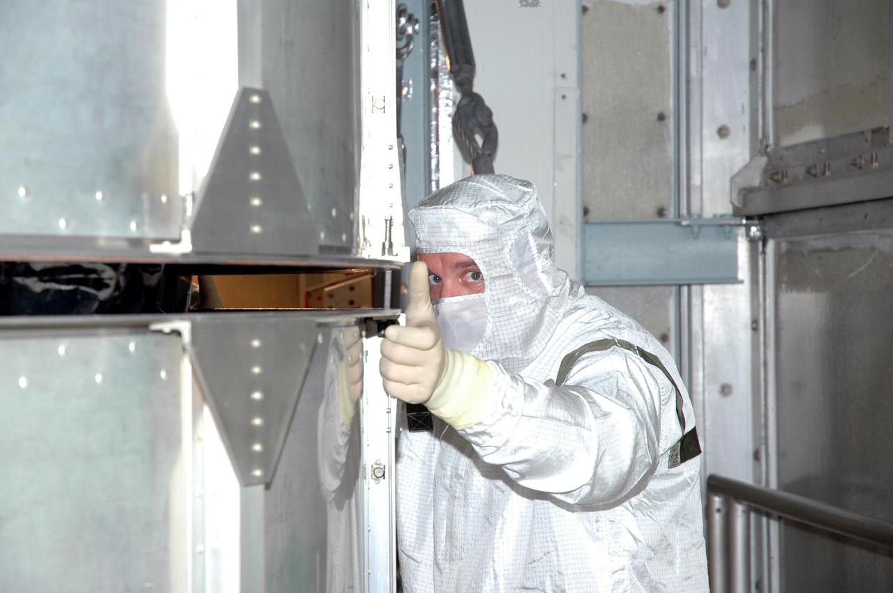 KENNEDY SPACE CENTER, FLA. -  Inside the mobile service tower on Launch Pad 17-A , Cape Canaveral Air Force Station, Fla., a Boeing technician gives the signal to lift the transport canister surrounding the Swift spacecraft.  A first-of-its-kind multi-wavelength observatory dedicated to the study of gamma-ray burst (GRB) science, Swift’s three instruments will work together to observe GRBs and afterglows in the gamma ray, X-ray, ultraviolet and optical wavebands. It is expected to observe more than 200 gamma-ray bursts - the most comprehensive study of GRB afterglows to date - during its 2-year mission.  Gamma-ray bursts are distant, yet fleeting explosions that appear to signal the births of black holes.  Swift is scheduled to launch aboard a Boeing Delta II rocket at the opening of a one-hour launch window beginning at 12:09 p.m. EST Nov. 17.