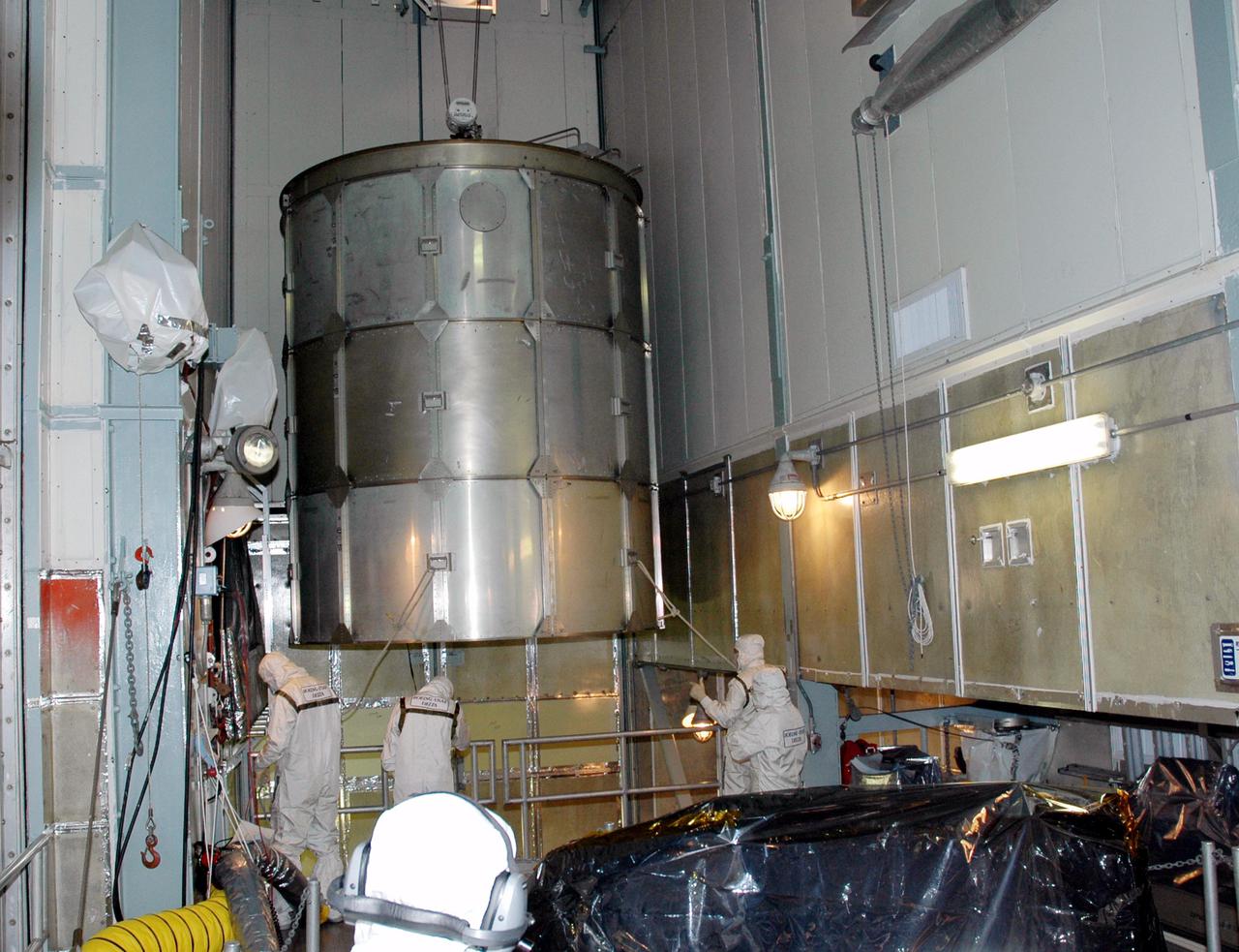 KENNEDY SPACE CENTER, FLA. -  Inside the mobile service tower on Launch Pad 17-A , Cape Canaveral Air Force Station, Fla., the upper portion of the transport canister is moved away after being lifted from the Swift spacecraft (lower right).  A first-of-its-kind multi-wavelength observatory dedicated to the study of gamma-ray burst (GRB) science, Swift’s three instruments will work together to observe GRBs and afterglows in the gamma ray, X-ray, ultraviolet and optical wavebands. It is expected to observe more than 200 gamma-ray bursts - the most comprehensive study of GRB afterglows to date - during its 2-year mission.  Gamma-ray bursts are distant, yet fleeting explosions that appear to signal the births of black holes.  Swift is scheduled to launch aboard a Boeing Delta II rocket at the opening of a one-hour launch window beginning at 12:09 p.m. EST Nov. 17.
