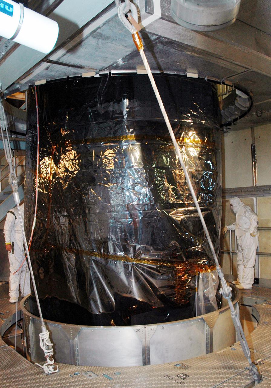 KENNEDY SPACE CENTER, FLA. -  Inside the mobile service tower on Launch Pad 17-A , Cape Canaveral Air Force Station, Fla.,  the Swift spacecraft still remains covered by plastic as Boeing technicians work to remove the rest of the transport canister surrounding it. A first-of-its-kind multi-wavelength observatory dedicated to the study of gamma-ray burst (GRB) science, Swift’s three instruments will work together to observe GRBs and afterglows in the gamma ray, X-ray, ultraviolet and optical wavebands. It is expected to observe more than 200 gamma-ray bursts - the most comprehensive study of GRB afterglows to date - during its 2-year mission.  Gamma-ray bursts are distant, yet fleeting explosions that appear to signal the births of black holes.  Swift is scheduled to launch aboard a Boeing Delta II rocket at the opening of a one-hour launch window beginning at 12:09 p.m. EST Nov. 17.