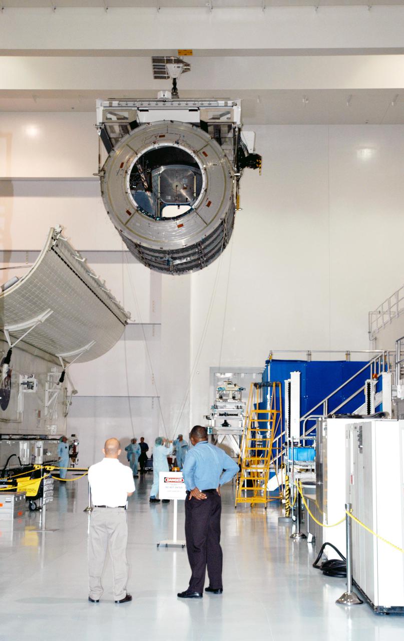 KENNEDY SPACE CENTER, FLA. -  In the Space Station Processing Facility, workers watch the progress of the Multi-Purpose Logistics Module Leonardo as it moves across the building to the Cargo Element Work Stand that Raffaello recently vacated.  The payload canister was a temporary location during the switch.  Three MPLMs were built by the Italian Space Agency - Donatello, Leonardo and Raffaello - to serve as a reusable logistics carrier and primary delivery system to resupply and return cargo requiring a pressurized environment to the International Space Station.