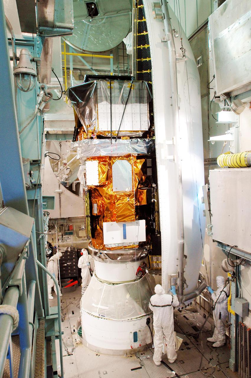 KENNEDY SPACE CENTER, FLA. - Boeing workers move the first part of the fairing into place around the Swift spacecraft inside the mobile service tower on Launch Pad 17-A, Cape Canaveral Air Force Station. The fairing is being installed around the payload for protection during launch and ascent. A Boeing Delta II rocket is the launch vehicle for the Swift spacecraft and its Gamma-Ray Burst Mission. Swift is a first-of-its-kind multi-wavelength observatory dedicated to the study of gamma-ray burst science. Its three instruments will work together to observe GRBs and afterglows in the gamma ray, X-ray, ultraviolet and optical wavebands. Swift is scheduled to launch Nov. 17 at 12:09 p.m. EST.