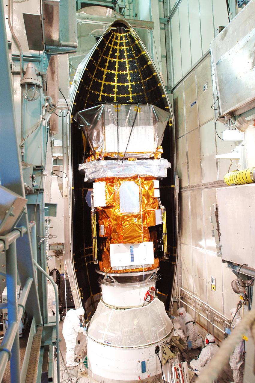 KENNEDY SPACE CENTER, FLA. - Boeing workers move the first part of the fairing into place around the Swift spacecraft inside the mobile service tower on Launch Pad 17-A, Cape Canaveral Air Force Station. The fairing is being installed around the payload for protection during launch and ascent. A Boeing Delta II rocket is the launch vehicle for the Swift spacecraft and its Gamma-Ray Burst Mission. Swift is a first-of-its-kind multi-wavelength observatory dedicated to the study of gamma-ray burst science. Its three instruments will work together to observe GRBs and afterglows in the gamma ray, X-ray, ultraviolet and optical wavebands. Swift is scheduled to launch Nov. 17 at 12:09 p.m. EST.