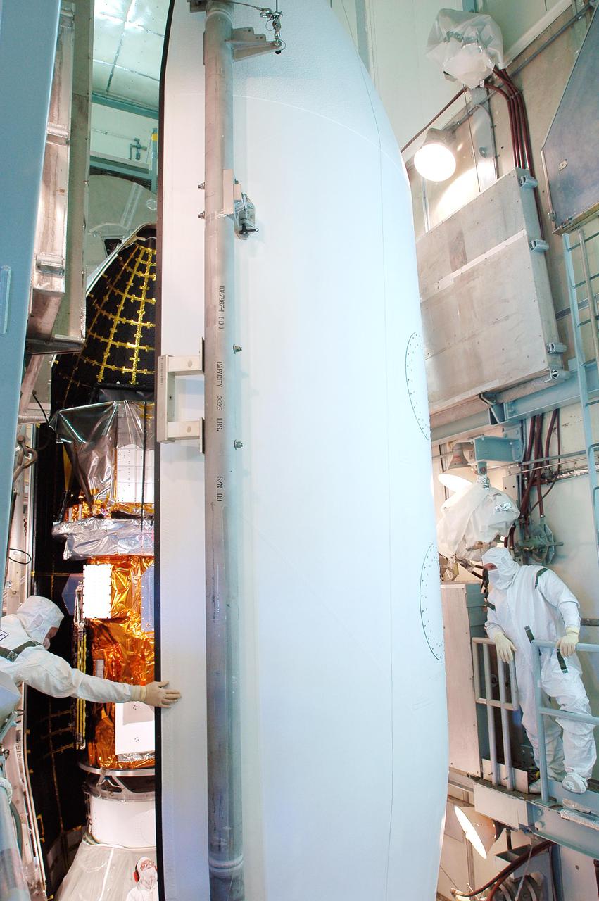 KENNEDY SPACE CENTER, FLA. - Boeing workers move the second section of the fairing around the Swift spacecraft inside the mobile service tower on Launch Pad 17-A, Cape Canaveral Air Force Station. The fairing is being installed around the payload for protection during launch and ascent. A Boeing Delta II rocket is the launch vehicle for the Swift spacecraft and its Gamma-Ray Burst Mission. Swift is a first-of-its-kind multi-wavelength observatory dedicated to the study of gamma-ray burst science. Its three instruments will work together to observe GRBs and afterglows in the gamma ray, X-ray, ultraviolet and optical wavebands. Swift is scheduled to launch Nov. 17 at 12:09 p.m. EST.