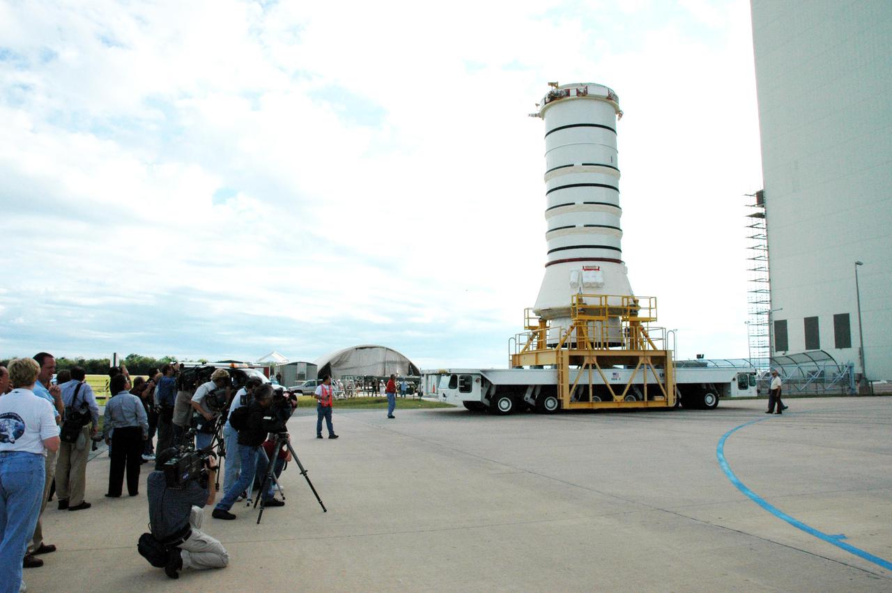 KENNEDY SPACE CENTER, FLA. -   The media station their cameras to capture the move of the aft skirt and lower segment of the Solid Rocket Booster for the Return to Flight mission STS-114.  A significant milestone in Return to Flight preparations, these first segments are moving from the Rotation Processing and Surge Facility to the Vehicle Assembly Building. Other segments will follow for stacking. Two SRBs support the liftoff of the Space Shuttle on a launch.  The twin 149-foot tall, 12-foot diameter SRBs provide the main propulsion system during launch to place the 180,000-pound orbiters in the proper orbit around the Earth.  They operate parallel with the Space Shuttle main engines for the first two minutes of flight and jettison away from the orbiter with help from the Booster Separation Motors, about 26.3 nautical miles above the Earth’s surface.