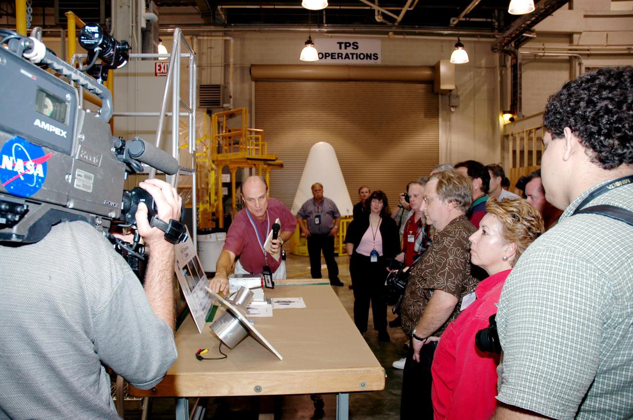 KENNEDY SPACE CENTER, FLA. -   The media tour Solid Rocket Booster (SRB) Assembly and Refurbishment Facility where Solid Rocket Booster (SRB) segments are refurbished.  In the background can be seen the frustum and nose cap of an SRB.  The media event featured the movement of the first SRB segments to the Vehicle Assembly Building for stacking for Return to Flight mission STS-114. Two SRBs support the liftoff of the Space Shuttle on a launch.  The twin 149-foot tall, 12-foot diameter SRBs provide the main propulsion system during launch to place the orbiters in the proper orbit around the Earth.  They operate parallel with the Space Shuttle main engines for the first two minutes of flight and jettison away from the orbiter, with help from the Booster Separation Motors, about 26.3 nautical miles above the Earth’s surface.