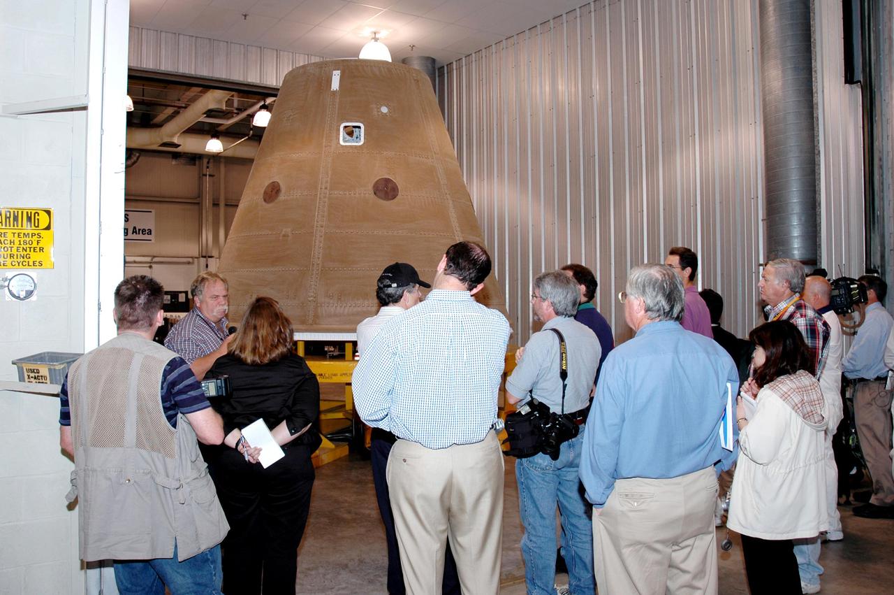 KENNEDY SPACE CENTER, FLA. -   The media tour Solid Rocket Booster (SRB) Assembly and Refurbishment Facility where Solid Rocket Booster (SRB) segments are refurbished.  In the background can be seen the frustum and nose cap of an SRB.  The media event featured the movement of the first SRB segments to the Vehicle Assembly Building for stacking for Return to Flight mission STS-114. Two SRBs support the liftoff of the Space Shuttle on a launch.  The twin 149-foot tall, 12-foot diameter SRBs provide the main propulsion system during launch to place the orbiters in the proper orbit around the Earth.  They operate parallel with the Space Shuttle main engines for the first two minutes of flight and jettison away from the orbiter, with help from the Booster Separation Motors, about 26.3 nautical miles above the Earth’s surface.