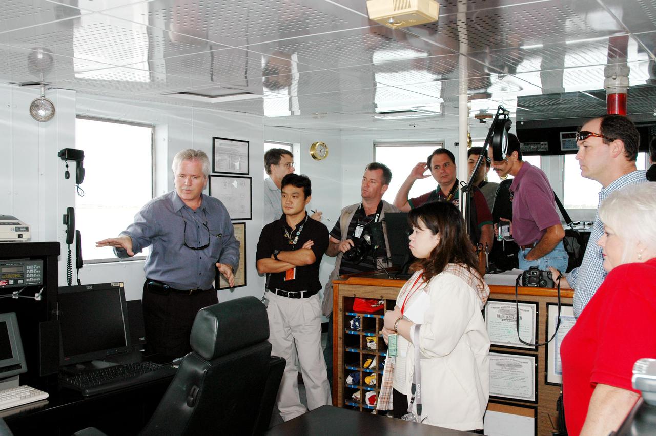 KENNEDY SPACE CENTER, FLA. -  The media visit the operations center on board the Freedom Star, one of the Solid Rocket Booster (SRB) retrieval ships.  The stop was part of a day-long event that featured the movement of the first SRB segments to the Vehicle Assembly Building for stacking for Return to Flight mission STS-114. Two SRBs support the liftoff of the Space Shuttle on a launch.  The twin 149-foot tall, 12-foot diameter SRBs provide the main propulsion system during launch to place the orbiters in the proper orbit around the Earth.  They operate parallel with the Space Shuttle main engines for the first two minutes of flight and jettison away from the orbiter, with help from the Booster Separation Motors, about 26.3 nautical miles above the Earth’s surface.