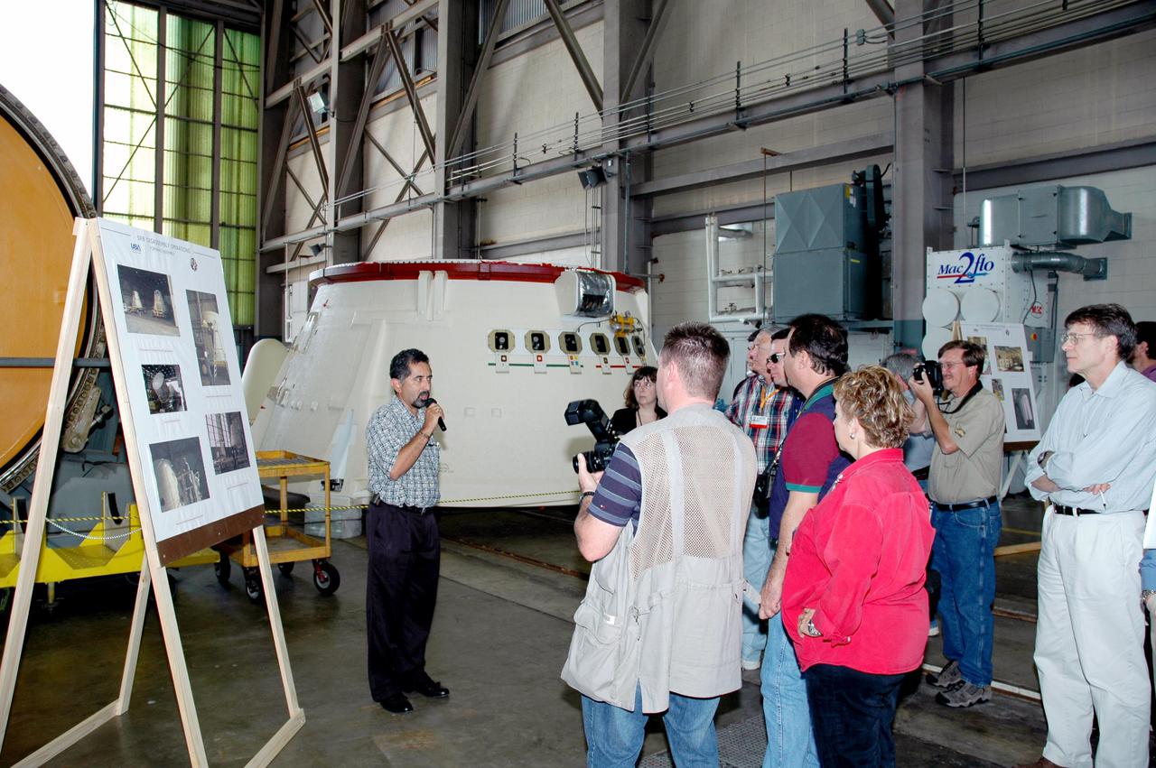 KENNEDY SPACE CENTER, FLA. -  The media tour Hangar AF where Solid Rocket Booster (SRB) segments are refurbished (an aft skirt is in the background).  The stop was part of a day-long event that featured the movement of the first SRB segments to the Vehicle Assembly Building for stacking for Return to Flight mission STS-114. Two SRBs support the liftoff of the Space Shuttle on a launch.  The twin 149-foot tall, 12-foot diameter SRBs provide the main propulsion system during launch to place the orbiters in the proper orbit around the Earth.  They operate parallel with the Space Shuttle main engines for the first two minutes of flight and jettison away from the orbiter, with help from the Booster Separation Motors, about 26.3 nautical miles above the Earth’s surface.