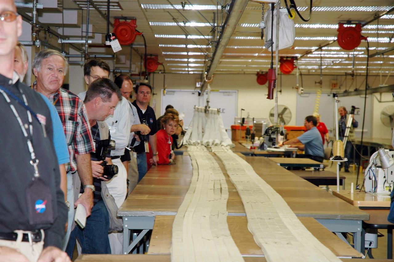KENNEDY SPACE CENTER, FLA. -  The media tour the Parachute Refurbishment Facility, which cleans and repairs the Solid Rocket Booster (SRB) parachutes after a Space Shuttle launch.   The stop was part of a day-long event that featured the movement of the first SRB segments to the Vehicle Assembly Building for stacking for Return to Flight mission STS-114. Two SRBs support the liftoff of the Space Shuttle on a launch.  The twin 149-foot tall, 12-foot diameter SRBs provide the main propulsion system during launch to place the orbiters in the proper orbit around the Earth.  They operate parallel with the Space Shuttle main engines for the first two minutes of flight and jettison away from the orbiter, with help from the Booster Separation Motors, about 26.3 nautical miles above the Earth’s surface.