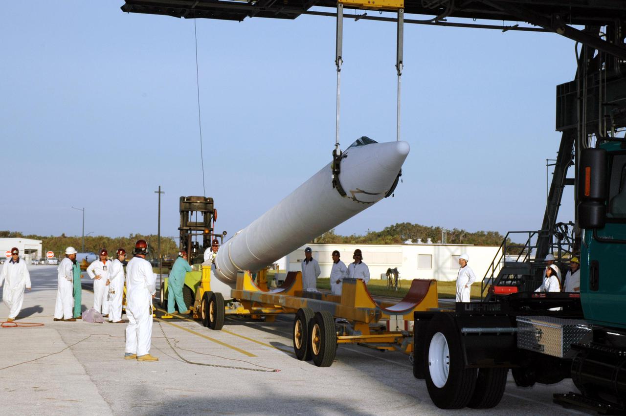 KENNEDY SPACE CENTER, FLA. - On Launch Pad 17-B, Cape Canaveral Air Force Station, Fla., a Solid Rocket Booster (SRB) is raised off a transporter. The SRB will be lifted up the mobile service tower and attached to the Boeing Delta II launch vehicle for launch of the Deep Impact spacecraft. A NASA Discovery mission, Deep Impact will probe beneath the surface of Comet Tempel 1 on July 4, 2005, when the comet is 83 million miles from Earth, and reveal the secrets of its interior. After releasing a 3- by 3-foot projectile to crash onto the surface, Deep Impact’s flyby spacecraft will collect pictures and data of how the crater forms, measuring the crater’s depth and diameter, as well as the composition of the interior of the crater and any material thrown out, and determining the changes in natural outgassing produced by the impact. It will send the data back to Earth through the antennas of the Deep Space Network. Deep Impact project management is handled by the Jet Propulsion Laboratory in Pasadena, Calif. The spacecraft is scheduled to launch Dec. 30, 2004.