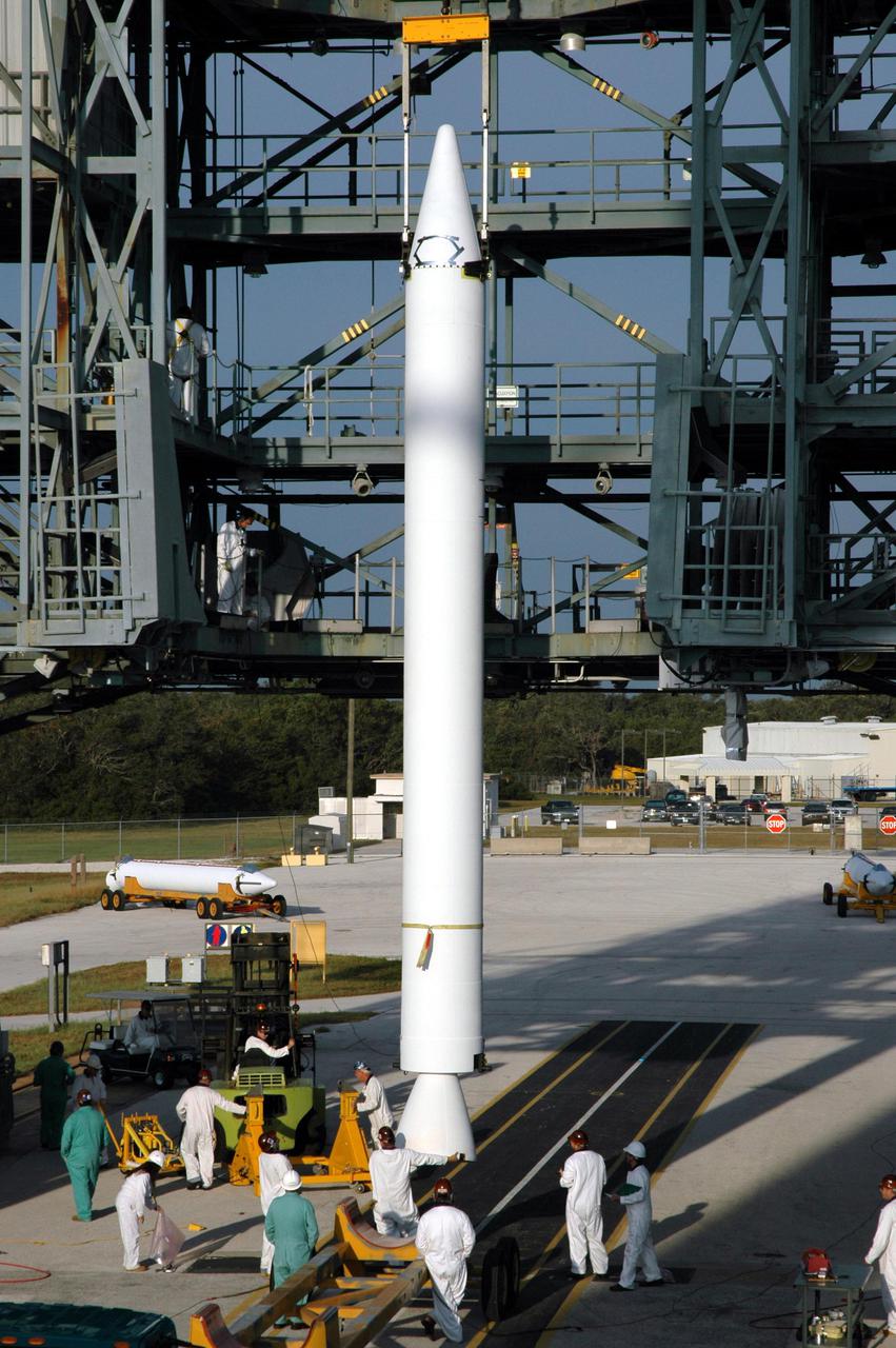 KENNEDY SPACE CENTER, FLA. - On Launch Pad 17-B, Cape Canaveral Air Force Station, Fla., workers prepare a Solid Rocket Booster (SRB) to be lifted up the mobile service tower and attached to the Boeing Delta II launch vehicle for launch of the Deep Impact spacecraft. A NASA Discovery mission, Deep Impact will probe beneath the surface of Comet Tempel 1 on July 4, 2005, when the comet is 83 million miles from Earth, and reveal the secrets of its interior. After releasing a 3- by 3-foot projectile to crash onto the surface, Deep Impact’s flyby spacecraft will collect pictures and data of how the crater forms, measuring the crater’s depth and diameter, as well as the composition of the interior of the crater and any material thrown out, and determining the changes in natural outgassing produced by the impact. It will send the data back to Earth through the antennas of the Deep Space Network. Deep Impact project management is handled by the Jet Propulsion Laboratory in Pasadena, Calif. The spacecraft is scheduled to launch Dec. 30, 2004.