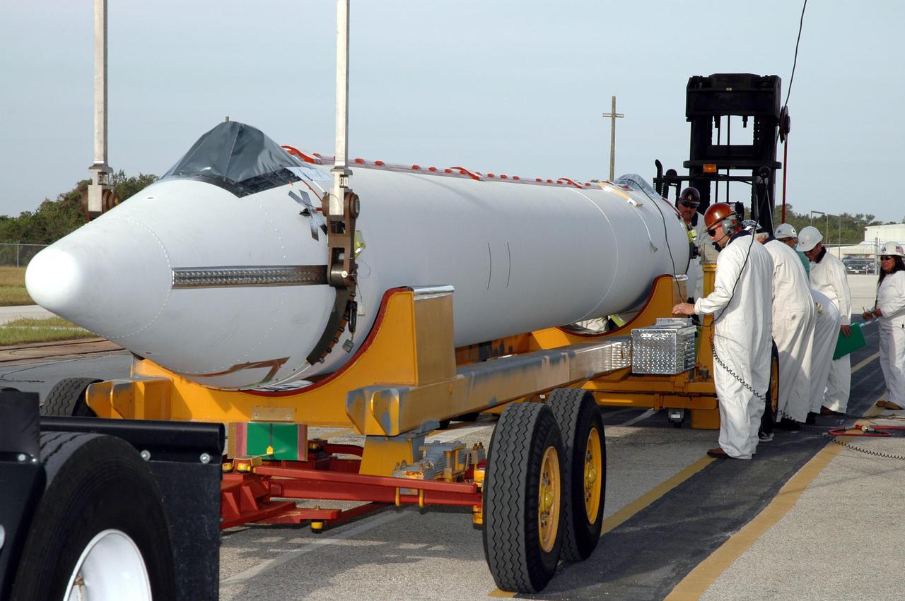 KENNEDY SPACE CENTER, FLA. - On Launch Pad 17-B, Cape Canaveral Air Force Station, Fla., another Solid Rocket Booster (SRB) arrives for attachment to the Boeing Delta II launch vehicle for launch of the Deep Impact spacecraft. A NASA Discovery mission, Deep Impact will probe beneath the surface of Comet Tempel 1 on July 4, 2005, when the comet is 83 million miles from Earth, and reveal the secrets of its interior. After releasing a 3- by 3-foot projectile to crash onto the surface, Deep Impact’s flyby spacecraft will collect pictures and data of how the crater forms, measuring the crater’s depth and diameter, as well as the composition of the interior of the crater and any material thrown out, and determining the changes in natural outgassing produced by the impact. It will send the data back to Earth through the antennas of the Deep Space Network. Deep Impact project management is handled by the Jet Propulsion Laboratory in Pasadena, Calif. The spacecraft is scheduled to launch Dec. 30, 2004.