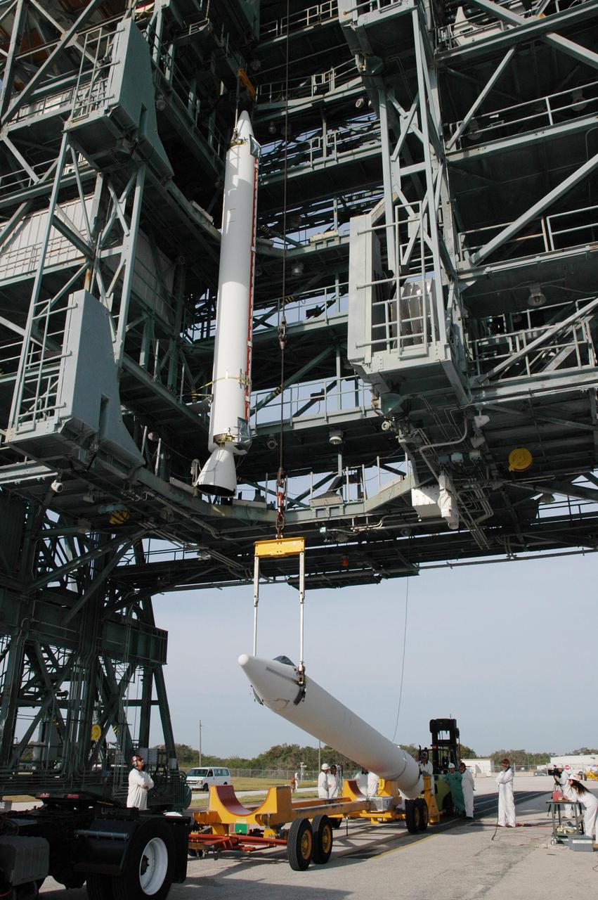 KENNEDY SPACE CENTER, FLA. - On Launch Pad 17-B, Cape Canaveral Air Force Station, Fla., a second Solid Rocket Booster (SRB) is raised off a transporter to be lifted up the mobile service tower. It will be attached to the Boeing Delta II launch vehicle for launch of the Deep Impact spacecraft. A NASA Discovery mission, Deep Impact will probe beneath the surface of Comet Tempel 1 on July 4, 2005, when the comet is 83 million miles from Earth, and reveal the secrets of its interior. After releasing a 3- by 3-foot projectile to crash onto the surface, Deep Impact’s flyby spacecraft will collect pictures and data of how the crater forms, measuring the crater’s depth and diameter, as well as the composition of the interior of the crater and any material thrown out, and determining the changes in natural outgassing produced by the impact. It will send the data back to Earth through the antennas of the Deep Space Network. Deep Impact project management is handled by the Jet Propulsion Laboratory in Pasadena, Calif. The spacecraft is scheduled to launch Dec. 30, 2004.