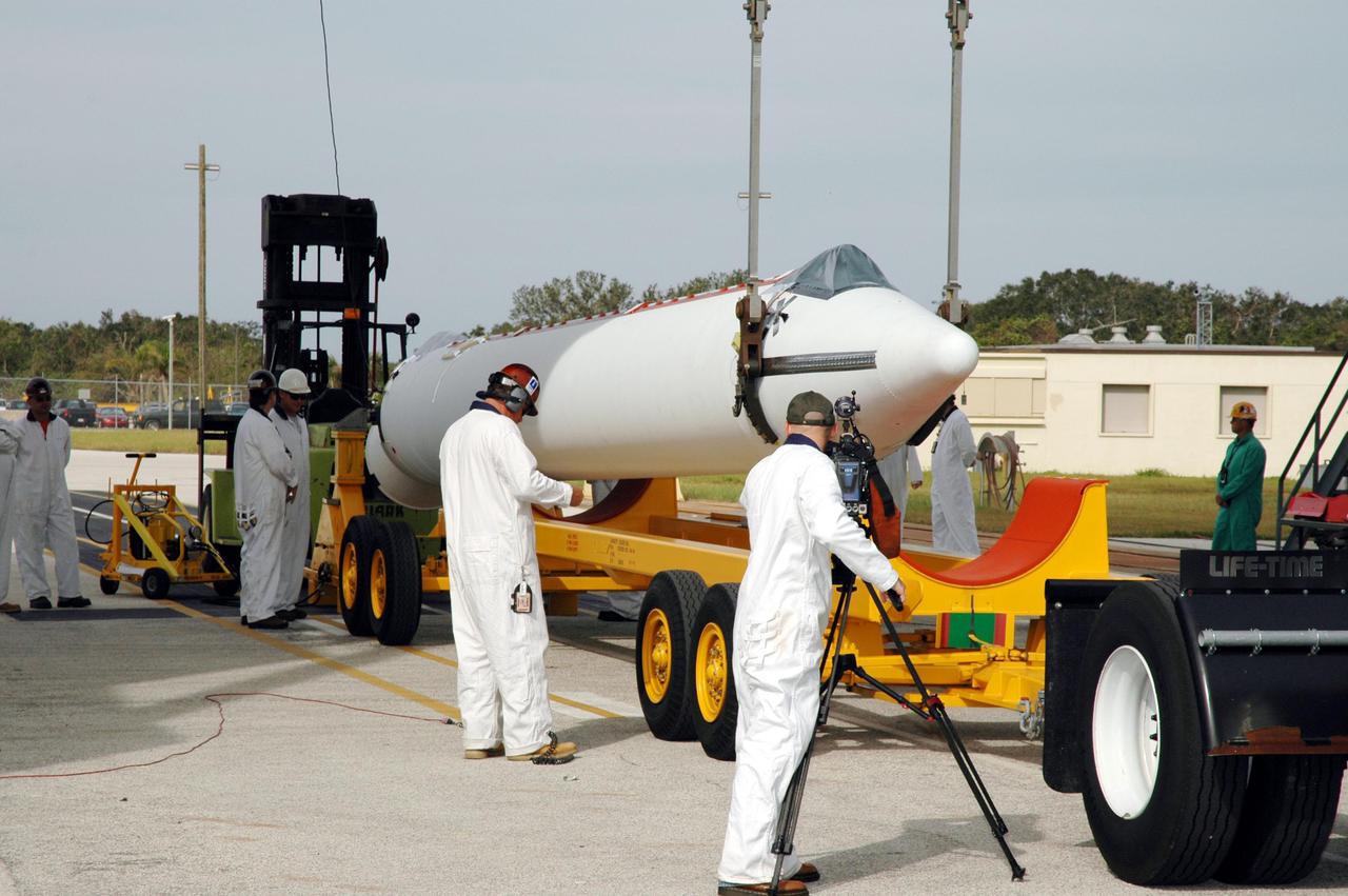 KENNEDY SPACE CENTER, FLA. - On Launch Pad 17-B, Cape Canaveral Air Force Station, Fla., another Solid Rocket Booster (SRB) arrives at the pad. It will be lifted up the mobile service tower and attached to the Boeing Delta II launch vehicle for launch of the Deep Impact spacecraft. A NASA Discovery mission, Deep Impact will probe beneath the surface of Comet Tempel 1 on July 4, 2005, when the comet is 83 million miles from Earth, and reveal the secrets of its interior. After releasing a 3- by 3-foot projectile to crash onto the surface, Deep Impact’s flyby spacecraft will collect pictures and data of how the crater forms, measuring the crater’s depth and diameter, as well as the composition of the interior of the crater and any material thrown out, and determining the changes in natural outgassing produced by the impact. It will send the data back to Earth through the antennas of the Deep Space Network. Deep Impact project management is handled by the Jet Propulsion Laboratory in Pasadena, Calif. The spacecraft is scheduled to launch Dec. 30, 2004.