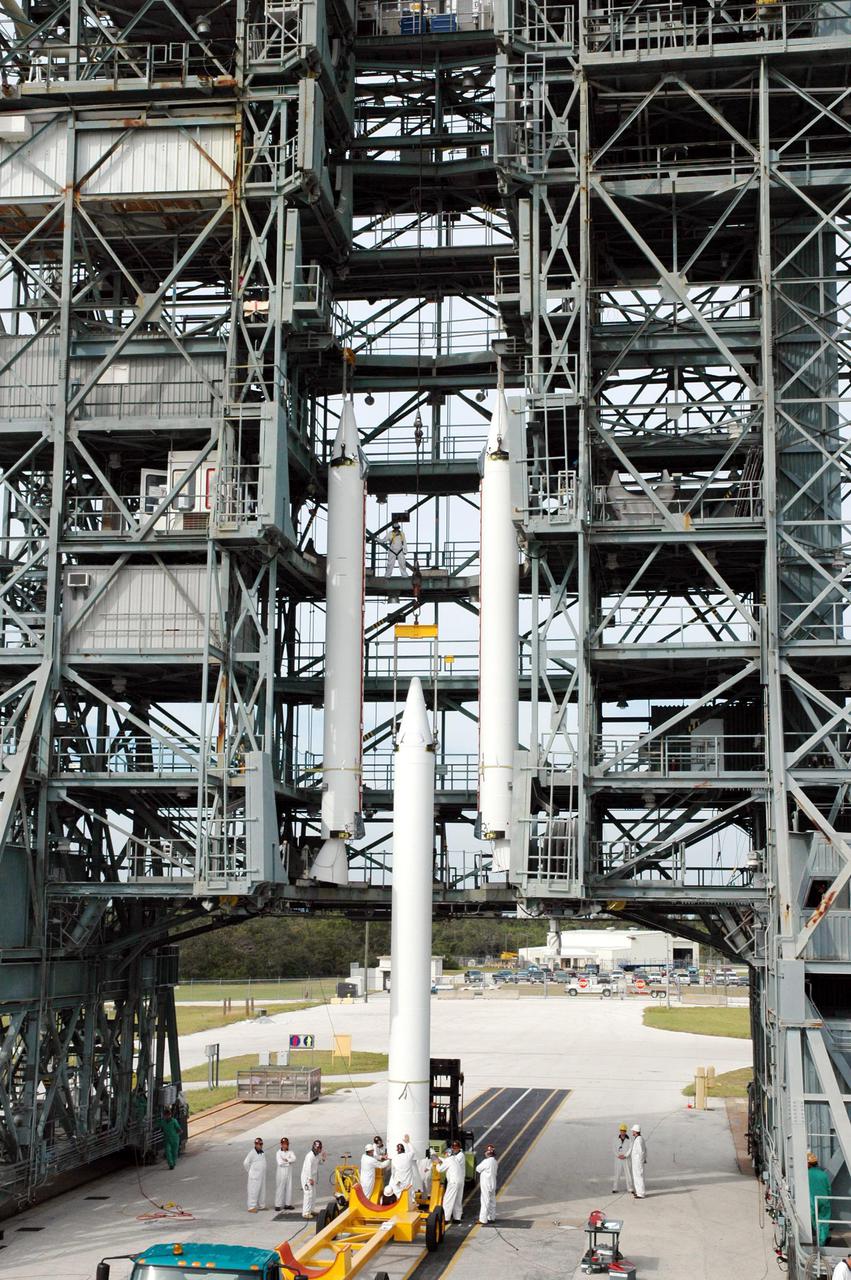 KENNEDY SPACE CENTER, FLA. - On Launch Pad 17-B, Cape Canaveral Air Force Station, Fla., a third Solid Rocket Booster (SRB) is prepared to join the two others in the mobile service tower. They will be attached to the Boeing Delta II launch vehicle for launch of the Deep Impact spacecraft. A NASA Discovery mission, Deep Impact will probe beneath the surface of Comet Tempel 1 on July 4, 2005, when the comet is 83 million miles from Earth, and reveal the secrets of its interior. After releasing a 3- by 3-foot projectile to crash onto the surface, Deep Impact’s flyby spacecraft will collect pictures and data of how the crater forms, measuring the crater’s depth and diameter, as well as the composition of the interior of the crater and any material thrown out, and determining the changes in natural outgassing produced by the impact. It will send the data back to Earth through the antennas of the Deep Space Network. Deep Impact project management is handled by the Jet Propulsion Laboratory in Pasadena, Calif. The spacecraft is scheduled to launch Dec. 30, 2004.