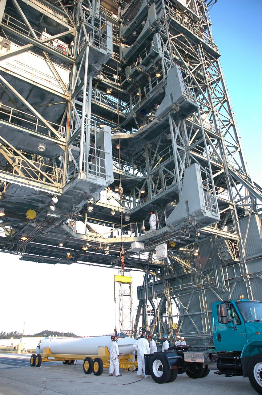 KENNEDY SPACE CENTER, FLA. - On Launch Pad 17-B, Cape Canaveral Air Force Station, Fla., the first of a second set of three Solid Rocket Boosters (SRBs) arrives. Three SRBs have already been hoisted up the mobile service tower and mated to the Boeing Delta II rocket that will launch the Deep Impact spacecraft. A NASA Discovery mission, Deep Impact will probe beneath the surface of Comet Tempel 1 on July 4, 2005, when the comet is 83 million miles from Earth, and reveal the secrets of its interior. After releasing an impactor on a course to hit the comet’s sunlit side, Deep Impact’s flyby spacecraft will collect pictures and data of how the crater forms, measure the crater’s depth and diameter, as well as the composition of the interior of the crater and any material thrown out, and determine the changes in natural outgassing produced by the impact. It will send the data back to Earth through the antennas of the Deep Space Network.