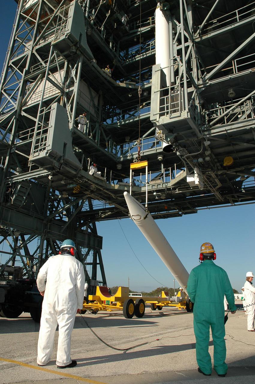 KENNEDY SPACE CENTER, FLA. - On Launch Pad 17-B, Cape Canaveral Air Force Station, Fla., the second in a set of three Solid Rocket Boosters (SRBs) is raised to a vertical position. The SRBs will be hoisted up the mobile service tower and join three others already mated to the Boeing Delta II rocket that will launch the Deep Impact spacecraft. A NASA Discovery mission, Deep Impact will probe beneath the surface of Comet Tempel 1 on July 4, 2005, when the comet is 83 million miles from Earth, and reveal the secrets of its interior. After releasing an impactor on a course to hit the comet’s sunlit side, Deep Impact’s flyby spacecraft will collect pictures and data of how the crater forms, measure the crater’s depth and diameter, as well as the composition of the interior of the crater and any material thrown out, and determine the changes in natural outgassing produced by the impact. It will send the data back to Earth through the antennas of the Deep Space Network.