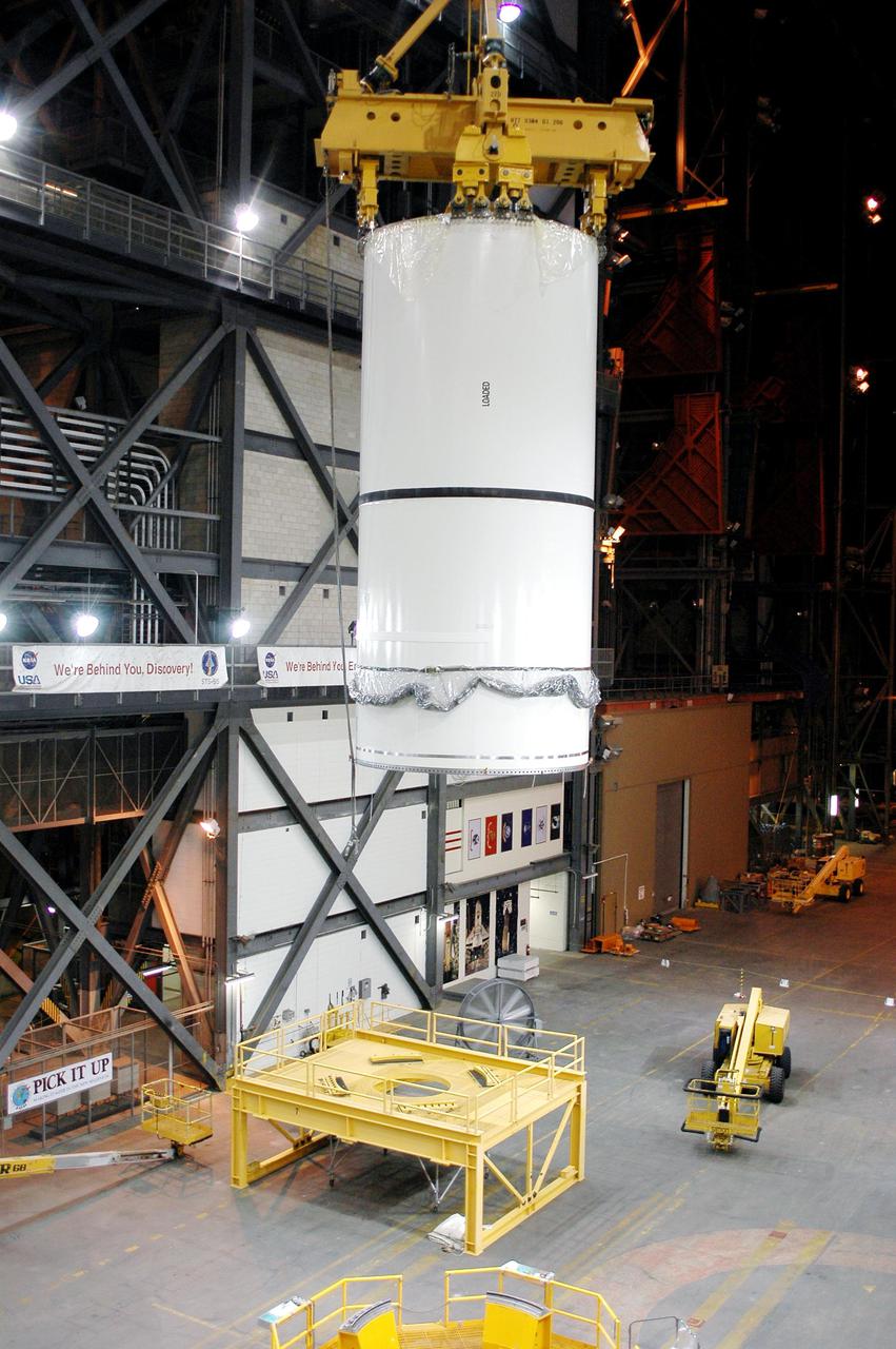 KENNEDY SPACE CENTER, FLA. -  In the transfer aisle of the Vehicle Assembly Building (VAB), a segment of a Solid Rocket Booster (SRB) is lifted from a transporter toward the 16th level.  This right aft center segment will be stacked with the aft booster that arrived in the VAB Nov. 22 for the Return to Flight mission STS-114. Two SRBs are stacked on the Mobile Launch Platform and later joined by the External Tank.. The twin 149-foot tall, 12-foot diameter SRBs provide the main propulsion system during launch. They operate parallel with the Space Shuttle main engines for the first two minutes of flight and jettison away from the orbiter with help from the Booster Separation Motors, about 26.3 nautical miles above the Earth’s surface.
