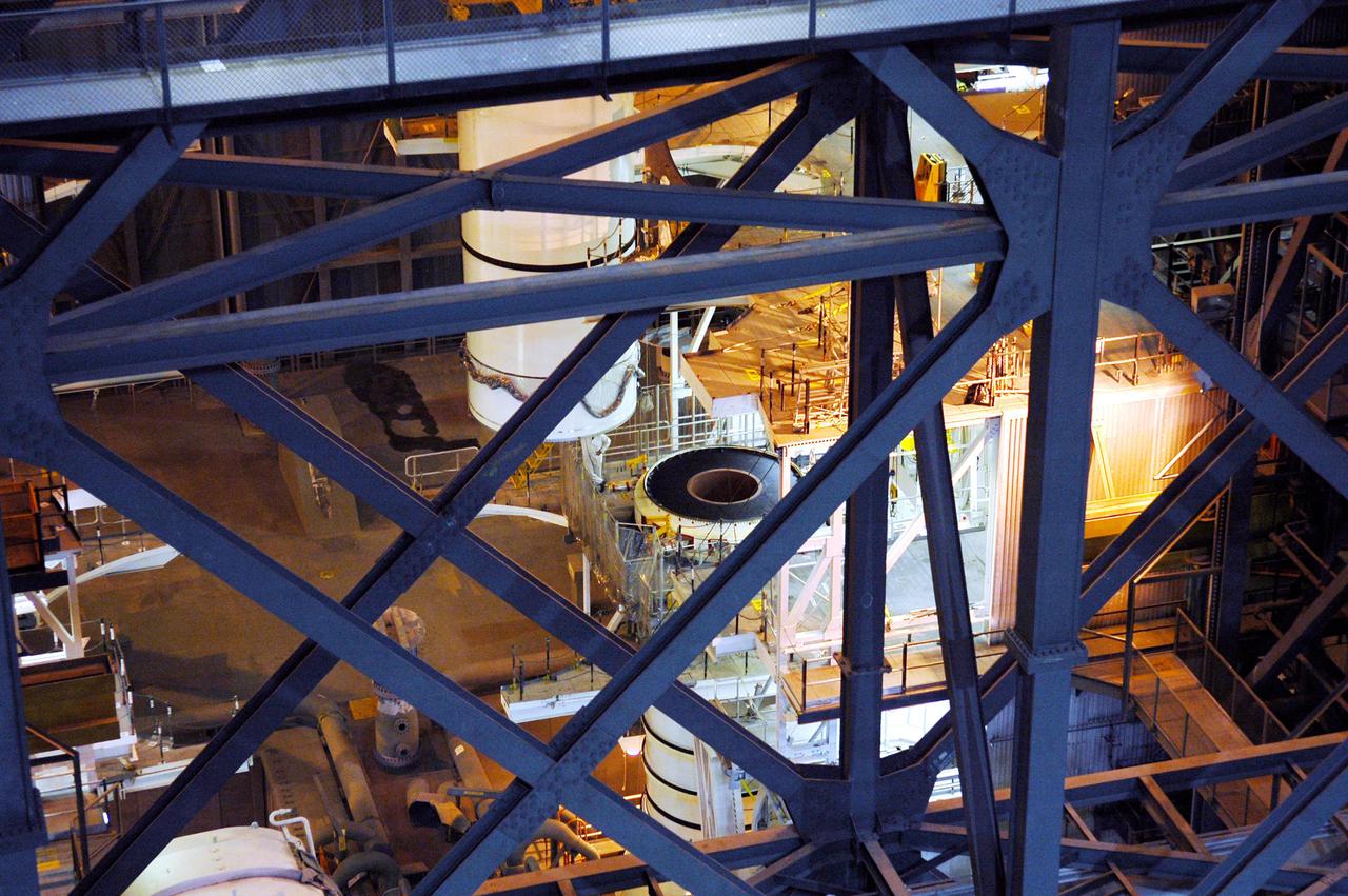 KENNEDY SPACE CENTER, FLA. -  In the Vehicle Assembly Building (VAB), the right aft center segment of a Solid Rocket Booster (SRB) is lowered toward the aft booster for mating. The aft booster arrived in the VAB Nov. 22 for the Return to Flight mission STS-114. Two SRBs are stacked on the Mobile Launch Platform and later joined by the External Tank.. The twin 149-foot tall, 12-foot diameter SRBs provide the main propulsion system during launch. They operate parallel with the Space Shuttle main engines for the first two minutes of flight and jettison away from the orbiter with help from the Booster Separation Motors, about 26.3 nautical miles above the Earth’s surface.