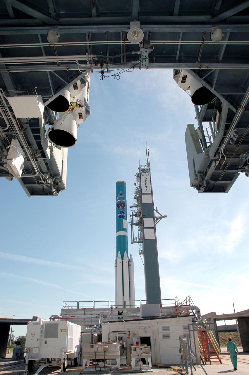 KENNEDY SPACE CENTER, FLA. - The mobile service tower with the final set of Solid Rocket Boosters (SRBs) rolls toward the Boeing Delta II rocket (in the background). The SRBs will be mated to the rocket, joining others for a complement of nine, to launch the Deep Impact spacecraft, scheduled for no earlier than Jan. 8, 2005. A NASA Discovery mission, Deep Impact will probe beneath the surface of Comet Tempel 1 on July 4, 2005, when the comet is 83 million miles from Earth, and reveal the secrets of its interior. After releasing an impactor on a course to hit the comet’s sunlit side, Deep Impact’s flyby spacecraft will collect pictures and data of how the crater forms, measure the crater’s depth and diameter, as well as the composition of the interior of the crater and any material thrown out, and determine the changes in natural outgassing produced by the impact. It will send the data back to Earth through the antennas of the Deep Space Network.