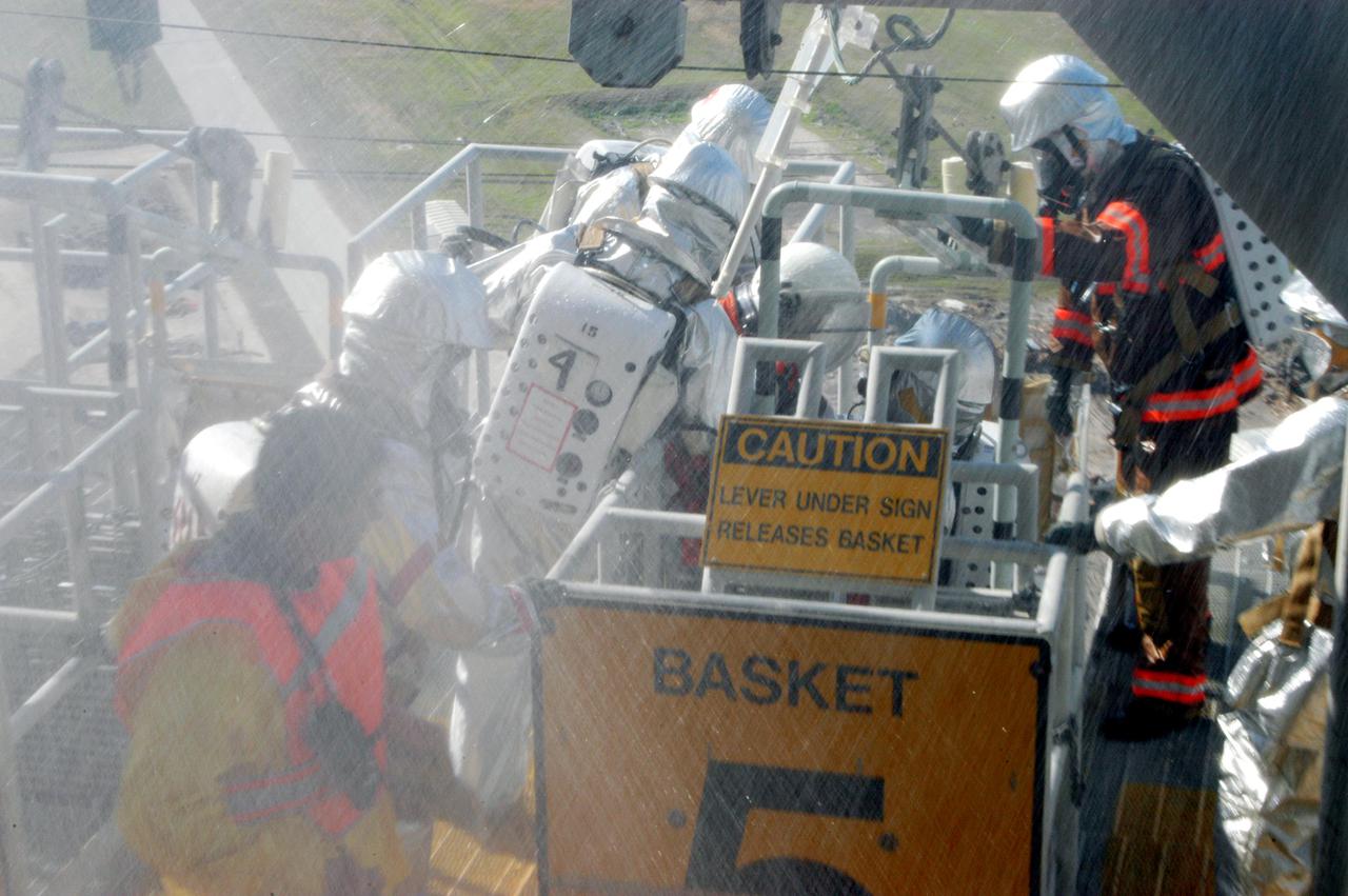 KENNEDY SPACE CENTER, FLA. -  On Launch Pad 39-A, a rescue force helps co-workers as part of an emergency egress scenario.  The four-hour exercise simulated normal launch countdown operations, with the added challenge of a fictitious event causing an evacuation of the vehicle and launch pad.  It tested the team’s rescue approaches on the Fixed Service Structure, slidewire basket evacuation, triage care and transportation of injured personnel to hospitals, as well as communications and coordination.