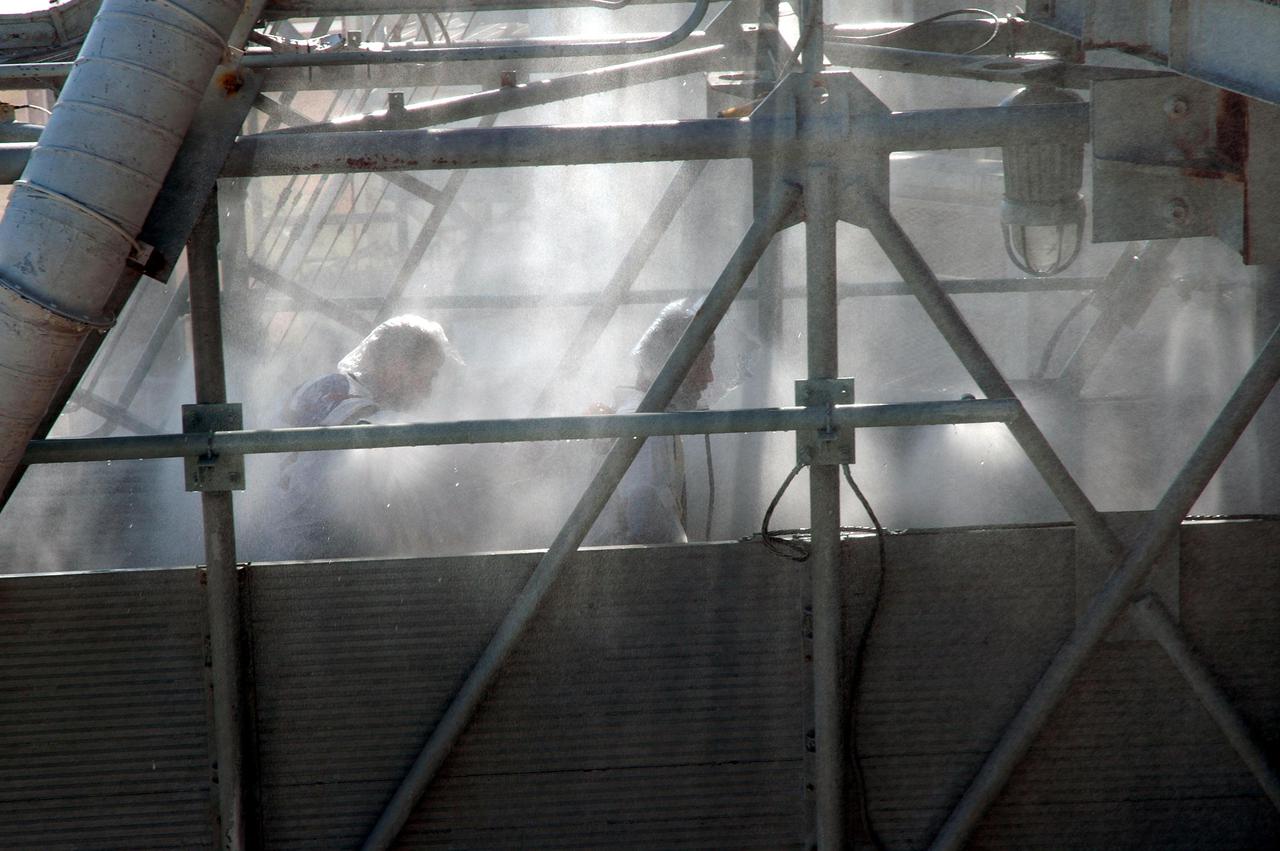 KENNEDY SPACE CENTER, FLA. - On Launch Pad 39A, astronaut-suited workers take part in an emergency egress scenario. The four-hour exercise simulated normal launch countdown operations, with the added challenge of a fictitious event causing an evacuation of the vehicle and launch pad. It tested the team’s rescue approaches on the Fixed Service Structure, slidewire basket evacuation, triage care and transportation of injured personnel to hospitals, as well as communications and coordination.