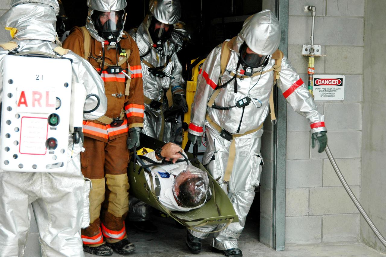KENNEDY SPACE CENTER, FLA. -  During a simulated launch countdown_emergency simulation on Launch Pad 39A, the rescue team carries “injured” astronaut-suited workers out of the pad bunker.  The four-hour exercise simulated normal launch countdown operations, with the added challenge of a fictitious event causing an evacuation of the vehicle and launch pad.  It tested the team’s rescue approaches on the Fixed Service Structure, slidewire basket evacuation, triage care and transportation of injured personnel to hospitals, as well as communications and coordination.