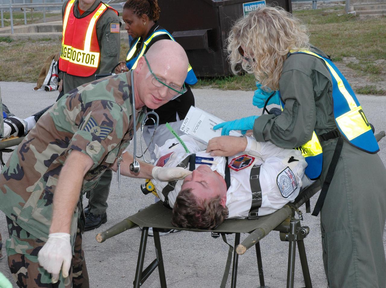 KENNEDY SPACE CENTER, FLA. -  During a simulated launch countdown_emergency simulation on Launch Pad 39A, the rescue team performs triage on “injured” astronaut-suited workers. Pad team members participated in the four-hour exercise simulating normal launch countdown operations, with the added challenge of a fictitious event causing an evacuation of the vehicle and launch pad.  The simulation tested the team’s rescue approaches on the Fixed Service Structure, slidewire basket evacuation, triage care and transportation of injured personnel to hospitals, as well as communications and coordination.