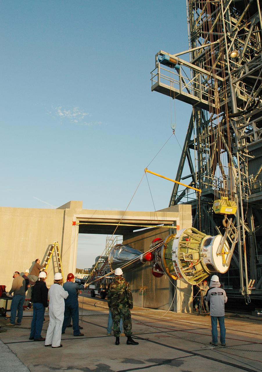 KENNEDY SPACE CENTER, FLA. - On Launch Pad 17-B at Cape Canaveral Air Force Station, workers help guide the second stage of the Boeing Delta II rocket as it is raised to vertical. The element will be lifted up the mobile service tower for mating to the Delta II, which will launch NASA’s Deep Impact spacecraft. A NASA Discovery mission, Deep Impact will probe beneath the surface of Comet Tempel 1 on July 4, 2005, when the comet is 83 million miles from Earth, and reveal the secrets of its interior. After releasing an impactor on a course to hit the comet’s sunlit side, Deep Impact’s flyby spacecraft will collect pictures and data of how the crater forms, measure the crater’s depth and diameter, as well as the composition of the interior of the crater and any material thrown out, and determine the changes in natural outgassing produced by the impact. It will send the data back to Earth through the antennas of the Deep Space Network.