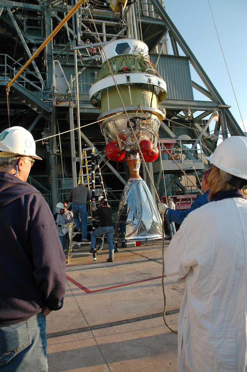 KENNEDY SPACE CENTER, FLA. -   On Launch Pad 17-B at Cape Canaveral Air Force Station, workers help guide the second stage of the Boeing Delta II rocket as it begins the lift up the mobile service tower.   The element will be mated to the Delta II, which will launch NASA’s Deep Impact spacecraft. A NASA Discovery mission, Deep Impact will probe beneath the surface of Comet Tempel 1 on July 4, 2005, when the comet is 83 million miles from Earth, and reveal the secrets of its interior.  After releasing an impactor on a course to hit the comet’s sunlit side, Deep Impact’s flyby spacecraft will collect pictures and data of how the crater forms, measure the crater’s depth and diameter, as well as the composition of the interior of the crater and any material thrown out, and determine the changes in natural outgassing produced by the impact.  It will send the data back to Earth through the antennas of the Deep Space Network.
