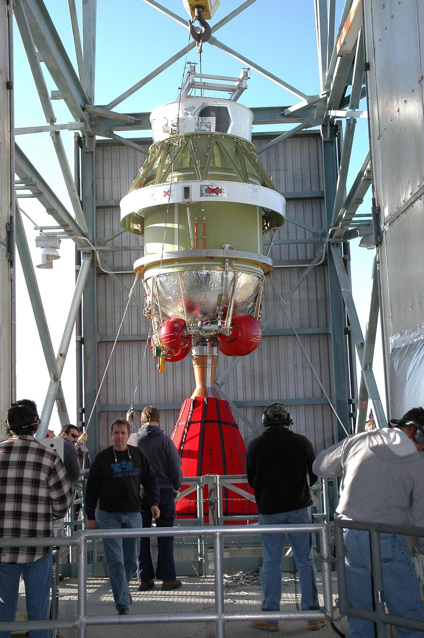 KENNEDY SPACE CENTER, FLA. - On Launch Pad 17-B at Cape Canaveral Air Force Station, the second stage of the Boeing Delta II rocket arrives at the top of the mobile service tower. The element will be mated to the Delta II, which will launch NASA’s Deep Impact spacecraft. A NASA Discovery mission, Deep Impact will probe beneath the surface of Comet Tempel 1 on July 4, 2005, when the comet is 83 million miles from Earth, and reveal the secrets of its interior. After releasing an impactor on a course to hit the comet’s sunlit side, Deep Impact’s flyby spacecraft will collect pictures and data of how the crater forms, measure the crater’s depth and diameter, as well as the composition of the interior of the crater and any material thrown out, and determine the changes in natural outgassing produced by the impact. It will send the data back to Earth through the antennas of the Deep Space Network.