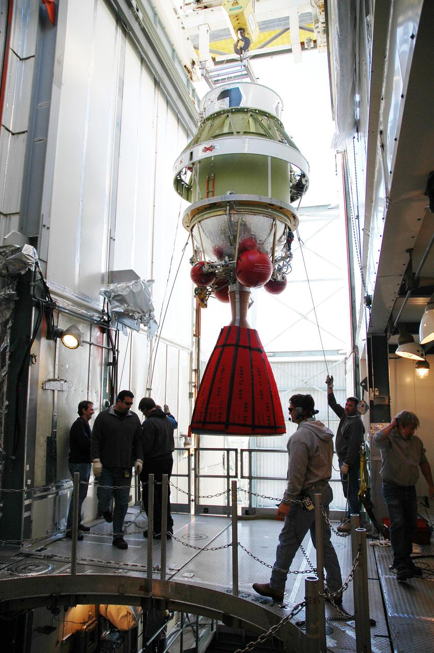KENNEDY SPACE CENTER, FLA. -   On Launch Pad 17-B at Cape Canaveral Air Force Station, the second stage of the Boeing Delta II rocket is moved toward the opening under which is the Boeing Delta II rocket.  The second stage will be mated to the Delta II, which will launch NASA’s Deep Impact spacecraft. A NASA Discovery mission, Deep Impact will probe beneath the surface of Comet Tempel 1 on July 4, 2005, when the comet is 83 million miles from Earth, and reveal the secrets of its interior.  After releasing an impactor on a course to hit the comet’s sunlit side, Deep Impact’s flyby spacecraft will collect pictures and data of how the crater forms, measure the crater’s depth and diameter, as well as the composition of the interior of the crater and any material thrown out, and determine the changes in natural outgassing produced by the impact.  It will send the data back to Earth through the antennas of the Deep Space Network.