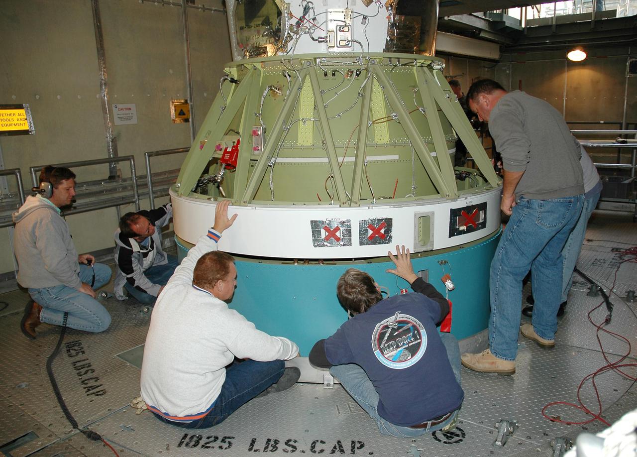 KENNEDY SPACE CENTER, FLA. -   On Launch Pad 17-B at Cape Canaveral Air Force Station, workers check areas of the second stage as it is mated to the Boeing Delta II rocket. The Delta II will launch NASA’s Deep Impact spacecraft. A NASA Discovery mission, Deep Impact will probe beneath the surface of Comet Tempel 1 on July 4, 2005, when the comet is 83 million miles from Earth, and reveal the secrets of its interior.  After releasing an impactor on a course to hit the comet’s sunlit side, Deep Impact’s flyby spacecraft will collect pictures and data of how the crater forms, measure the crater’s depth and diameter, as well as the composition of the interior of the crater and any material thrown out, and determine the changes in natural outgassing produced by the impact.  It will send the data back to Earth through the antennas of the Deep Space Network.