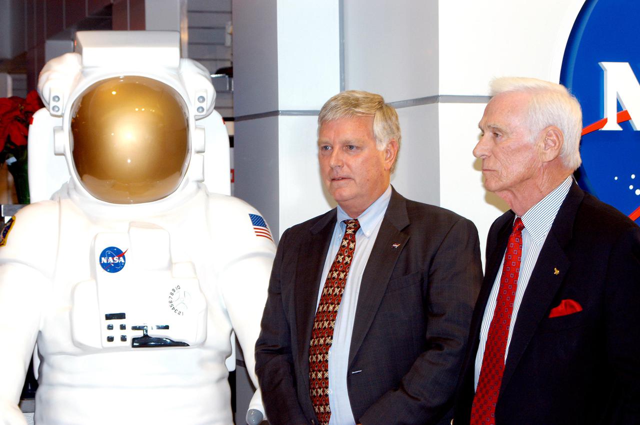 KENNEDY SPACE CENTER, FLA. -  Center Director Jim Kennedy (left) and Apollo 17 Commander Gene Cernan stand next to a display of an astronaut at the new Kennedy Space Center Store at Orlando International Airport.  NASA’s Kennedy Space Center Director Jim Kennedy and Apollo 17 Commander Gene Cernan participated in the grand opening ceremony of the store that will help educate millions of airport visitors about America’s space program and the Vision for Space Exploration.  The store is operated by Kennedy Space Center Visitor Complex concessionaire Delaware North Parks and Resorts.